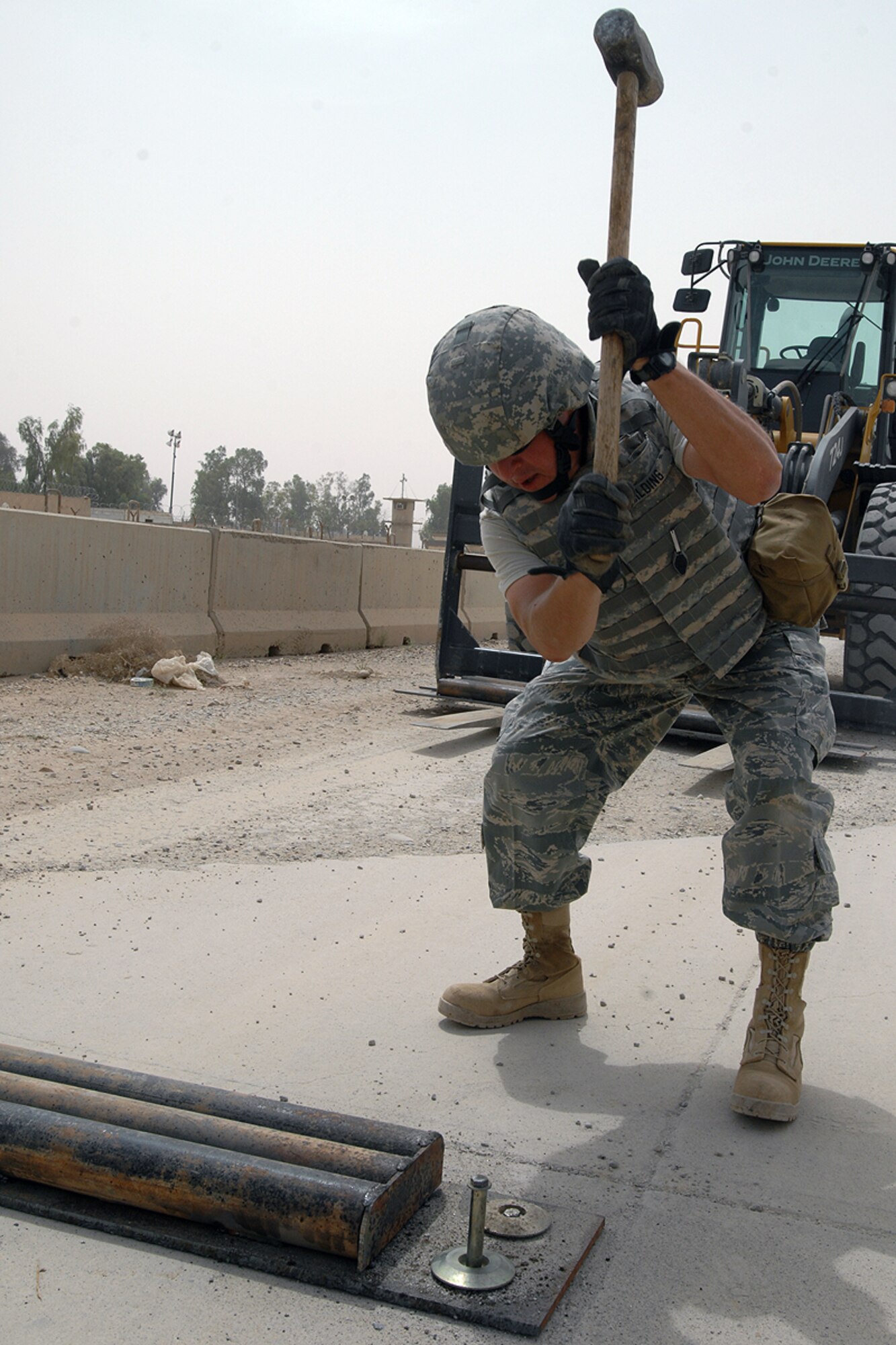 KIRKUK REGIONAL AIR BASE, Iraq -- Tech. Sgt. Mark Gilding, 506th Expeditionary Civil Engineer Squadron heavy equipment NCOIC, installs new speed bumps here May 22.  The speed bumps are meant to not only control speed mitigation, but increase the safety of the security forces Airmen manning the gates and protect more than 6,000 servicemembers deployed here. Sergeant Gilding, a Colorado Springs, Colo., native, is deployed here from Peterson Air Force Base, Colo. (U.S. Air Force photo / Staff Sgt. Eunique Stevens) 