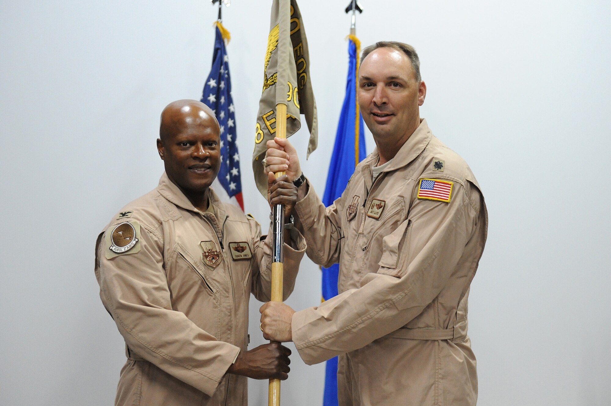 SOUTHWEST ASIA - Col. Soren Jones, 380th Expeditionary Operations Group, commander, passes the flag of the 908th Expeditionary Air Refueling Squadron to Lt. Col. Matthew Lloyd as he takes command, May 21 at an undisclosed location in Southwest Asia. Colonel Lloyd joins the 380th Air Expeditionary Wing from Travis AFB, Calif. to lead the 908th EARS. (U.S. Air Force photo by Senior Airman Brian J. Ellis) (Released)