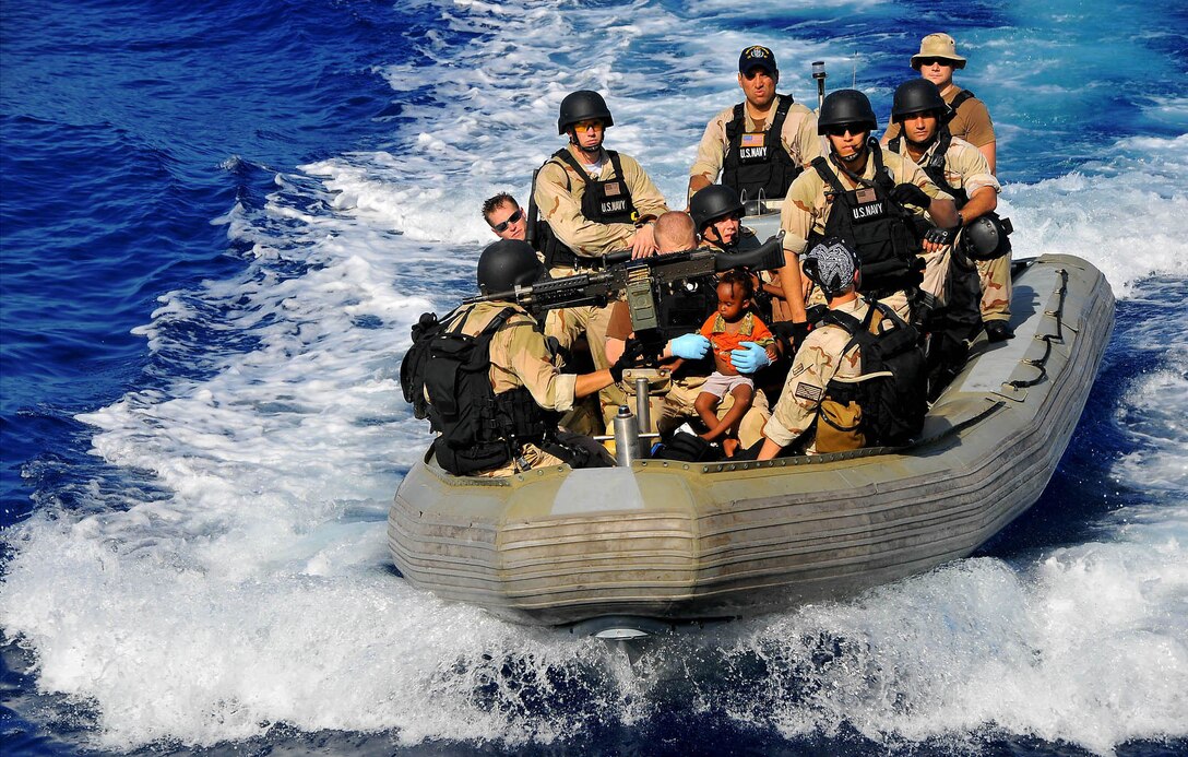 U.S. Navy sailors assigned to the USS Lake Champlain's visit, board, search and seizure team transport Somali migrant children to their guided-missile cruiser after rescuing them from a disabled skiff in the Gulf of Aden, May 24, 2009. The skiff, originally ferrying 52 passengers, was spotted in distress by the USS Lake Champlain helicopter pilots patrolling the area. The USS Lake Champlain is deployed as part of the USS Boxer Expeditionary Strike Group supporting maritime security operations in the U.S. 5th Fleet area of responsibility.