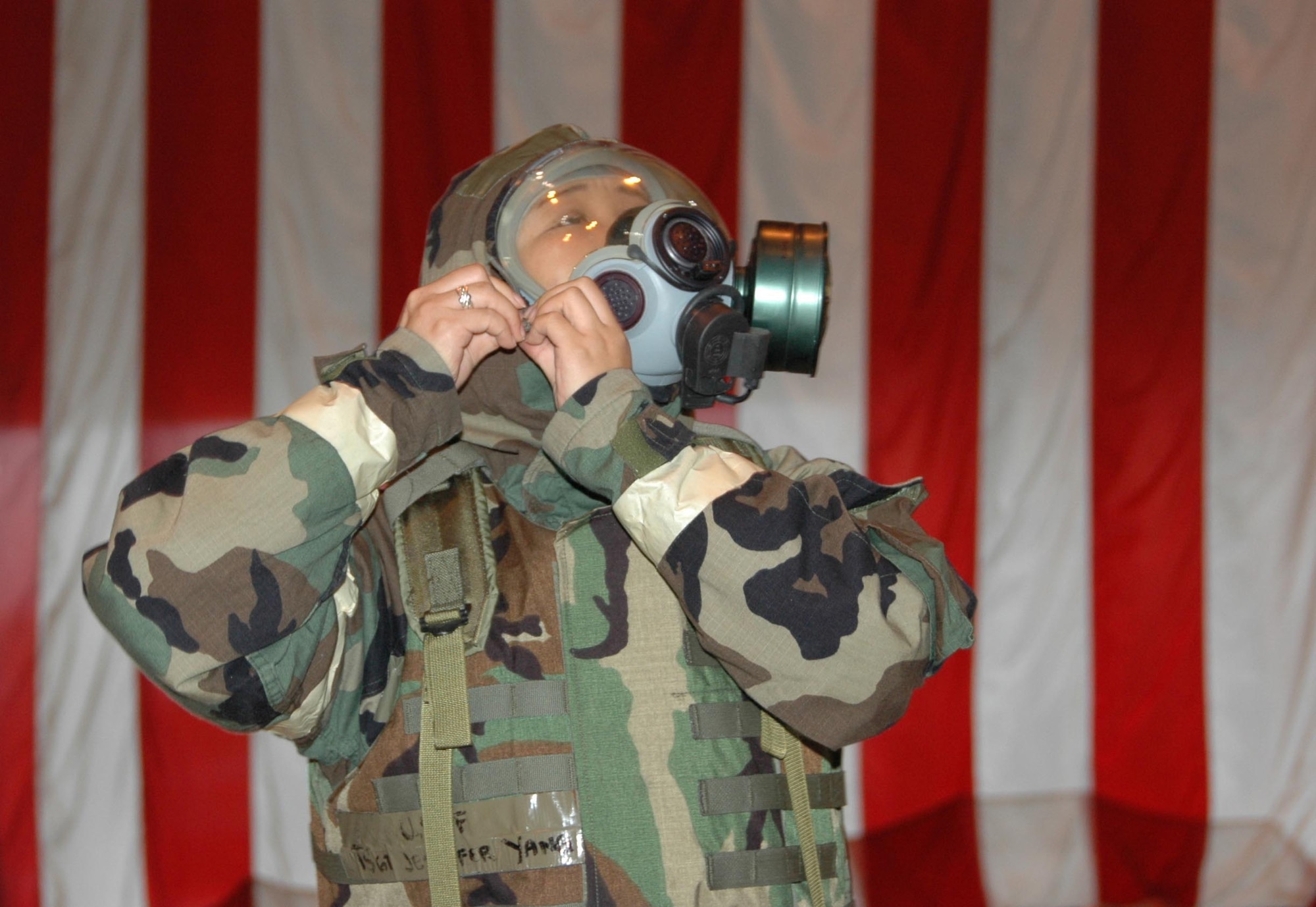 Technical Sgt. Jennifer Yang, a readiness assistant with the 514th Civil Engineering Squadron, secures her gas mask while demonstrating proper wear of mobility gear during the final Operational Readiness Inspection pep rally held May 17. (U.S. Air Force photo/Staff Sgt. Monica Dalberg)