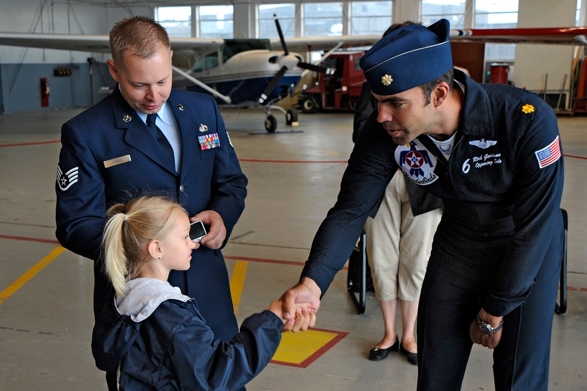 Maj. Rick Goodman, Thunderbird pilot no. 6 shakes hands with Nykol Hogan as her father, Staff SSgt.Travis Hogan, 21st Space Wing Protocol looks on. Friends and family of re-enlistees had the unique opportunity to meet Air Force Thunderbirds on Memorial Day. (Air Force photo by Craig Denton)
