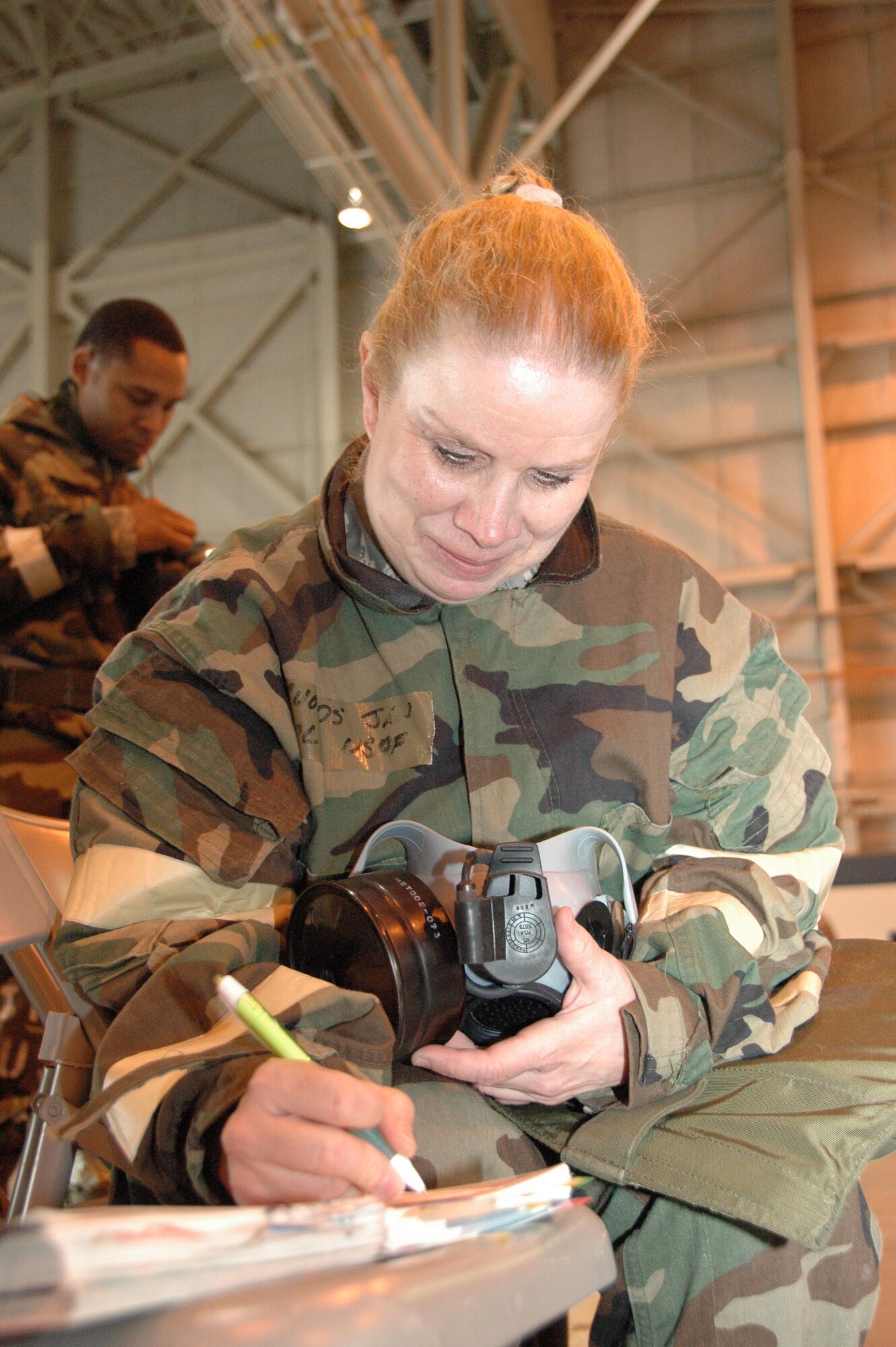 Col. Jan Rhoads, chief nurse at the 514th Aeromedical Staging Squadron at Joint Base McGuire-Dix-Lakehurst, inspects her gas mask during the final Operational Readiness Inspection pep rally held May 17. (U.S. Air Force photo/Staff Sgt. Monica Dalberg)