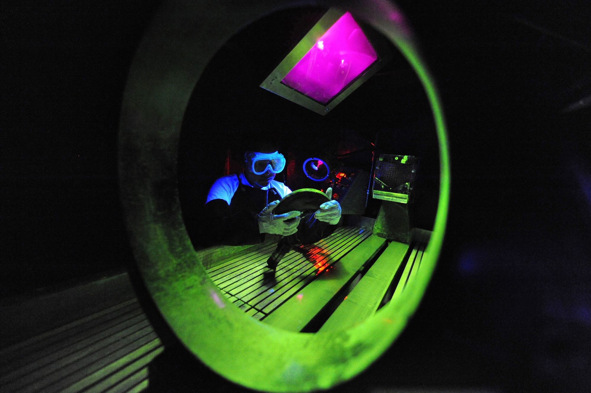 U.S. Air Force Senior Airman Lilia Linares utilizes a fluorescent magnetic particle process to inspect an aerospace ground equipment hook for cracks at Charleston Air Force Base S.C., May 27, 2009. The non-destructive inspection section inspects more than 40,000 pieces of weapon systems and non-weapon systems assets a year. Airman Linares is a non-destructive inspection journeyman with the 437th Maintenance Squadron. (U.S. Air Force photo by James M. Bowman)(Released)
