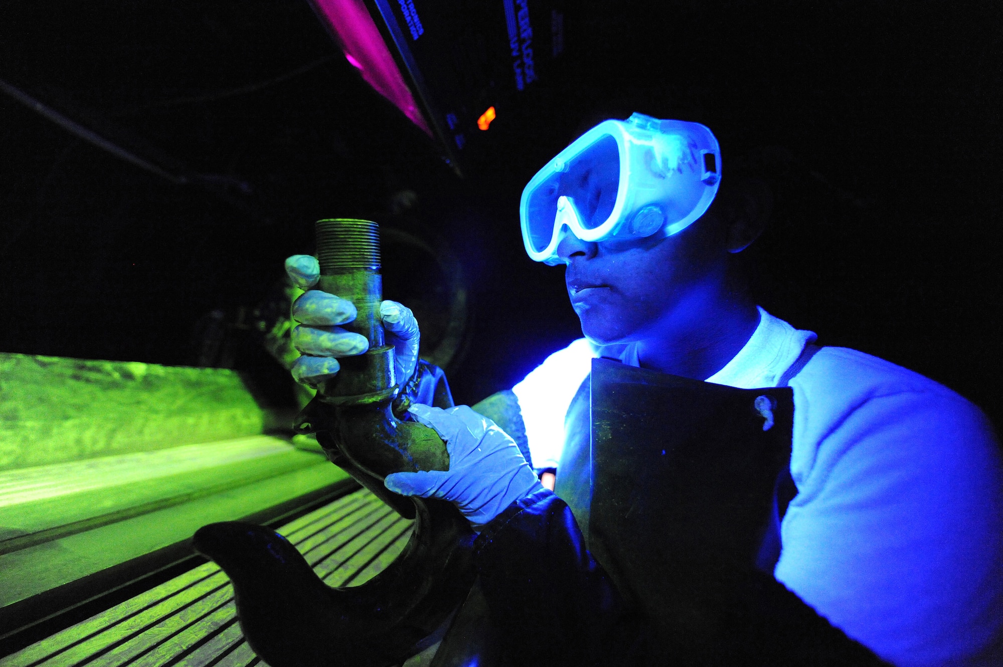 U.S. Air Force Senior Airman Lilia Linares utilizes a fluorescent magnetic particle process to inspect an aerospace ground equipment hook for cracks at Charleston Air Force Base S.C., May 27, 2009. The non-destructive inspection section inspects more than 40,000 pieces of weapon systems and non-weapon systems assets a year. Airman Linares is a non-destructive inspection journeyman with the 437th Maintenance Squadron. (U.S. Air Force photo by James M. Bowman)(Released)
