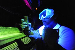 Senior Airman Lilia Linares utilizes a fluorescent magnetic particle process to inspect an aerospace ground equipment hook for cracks at Charleston Air Force Base, S.C., May 27, 2009. The non-destructive inspection section inspects more than 40,000 pieces of weapon systems and non-weapon systems assets a year. Airman Linares is a non-destructive inspection journeyman with the 437th Maintenance Squadron. (U.S. Air Force photo/James M. Bowman)