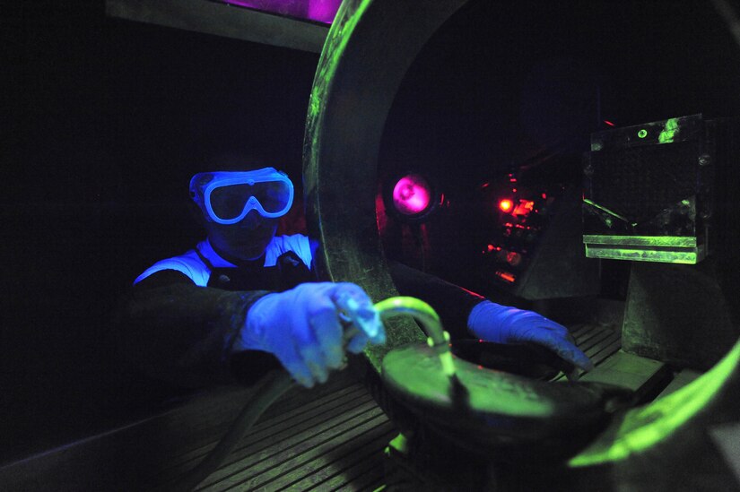 U.S. Air Force Senior Airman Lilia Linares utilizes a fluorescent magnetic particle process to inspect an aerospace ground equipment hook for cracks at Charleston Air Force Base S.C., May 27, 2009. The non-destructive inspection section inspects more than 40,000 pieces of weapon systems and non-weapon systems assets a year. Airman Linares is a non-destructive inspection journeyman with the 437th Maintenance Squadron. (U.S. Air Force photo by James M. Bowman)(Released)

