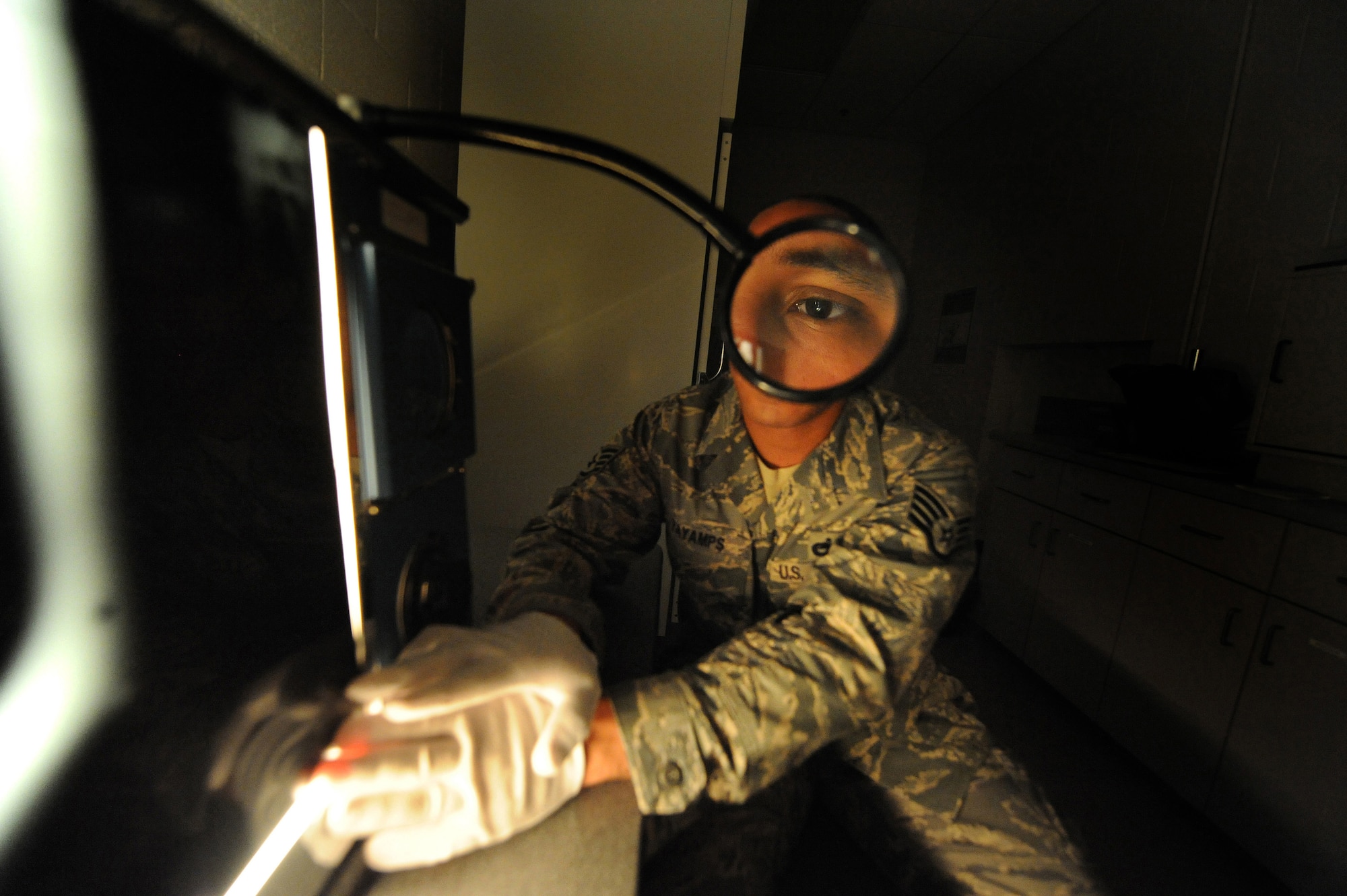 U.S. Air Force Staff Sgt. Kenny Payamps inspects radiography film of a carbon fiber composite panel for foreign objects at Charleston Air Force Base S.C., May 27, 2009. The non-destructive inspection section is responsible for ensuring structural integrity on both weapons and non-weapons systems. Sergeant Payamps is a non-destructive craftsman with the 437th Maintenance Squadron. (U.S. Air Force photo by James M. Bowman)(Released)

