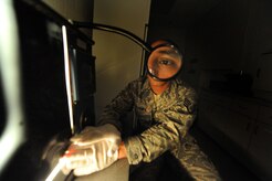 Staff Sgt. Kenny Payamps inspects the radiography film of a carbon fiber composite panel for foreign objects at Charleston Air Force Base, S.C., May 27, 2009. The non-destructive inspection section is responsible for ensuring structural integrity on both weapons and non-weapons systems. Sergeant Payamps is a non-destructive craftsman with the 437th Maintenance Squadron. (U.S. Air Force photo/James M. Bowman)