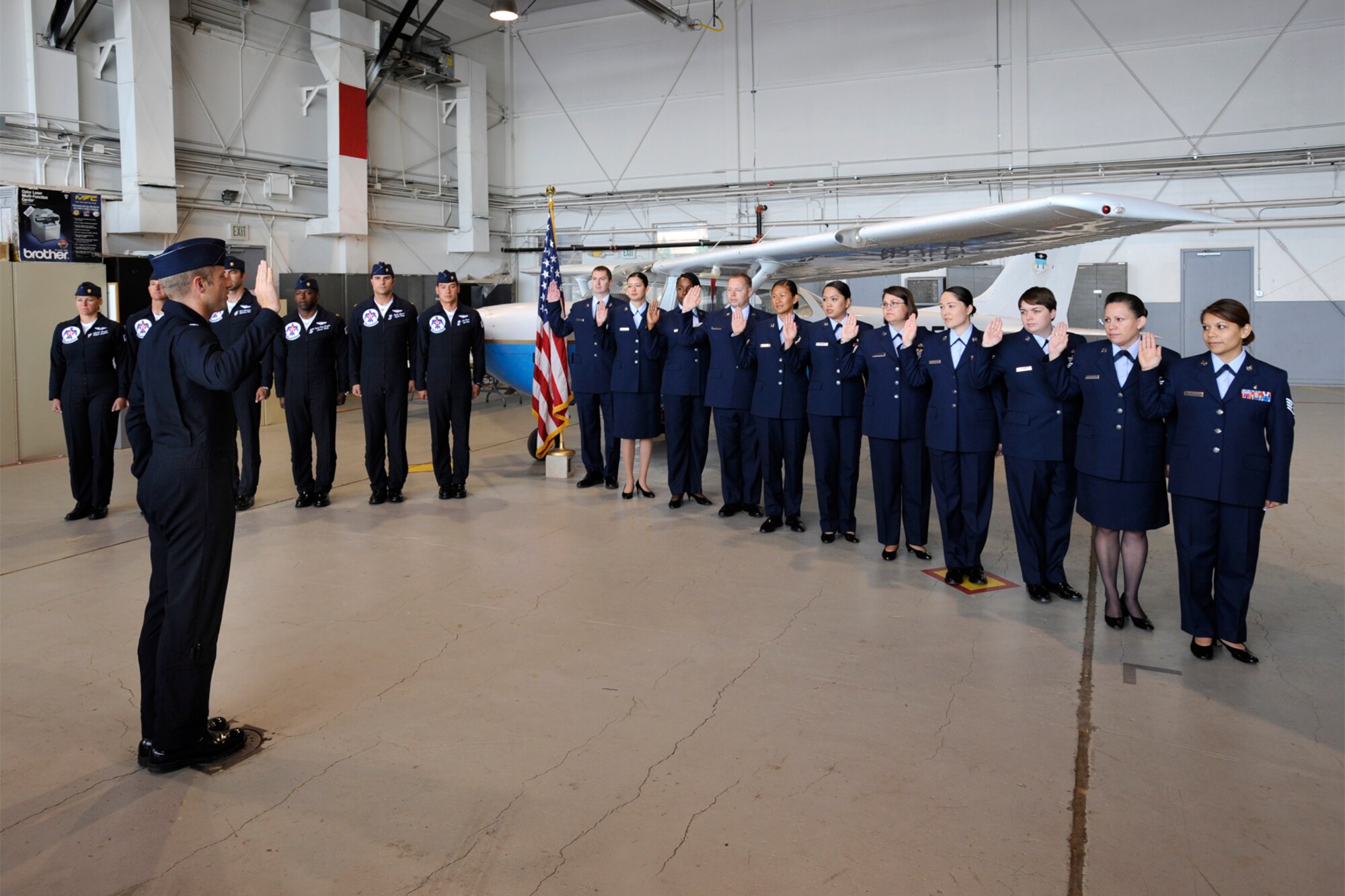 Lt. Col. Greg Thomas, Thunderbird commander, leads Peterson Airmen through the oath of enlistment in a reenlistment ceremony in hanger 119 on Memorial Day. Peterson Airmen and their families had the opportunity to visit face-to-face with Colonel Thomas and the other Thunderbird polits who were in town to perform at the Air Force Academy graduation ceremony May 27. (Air Force photo by Craig Denton)

