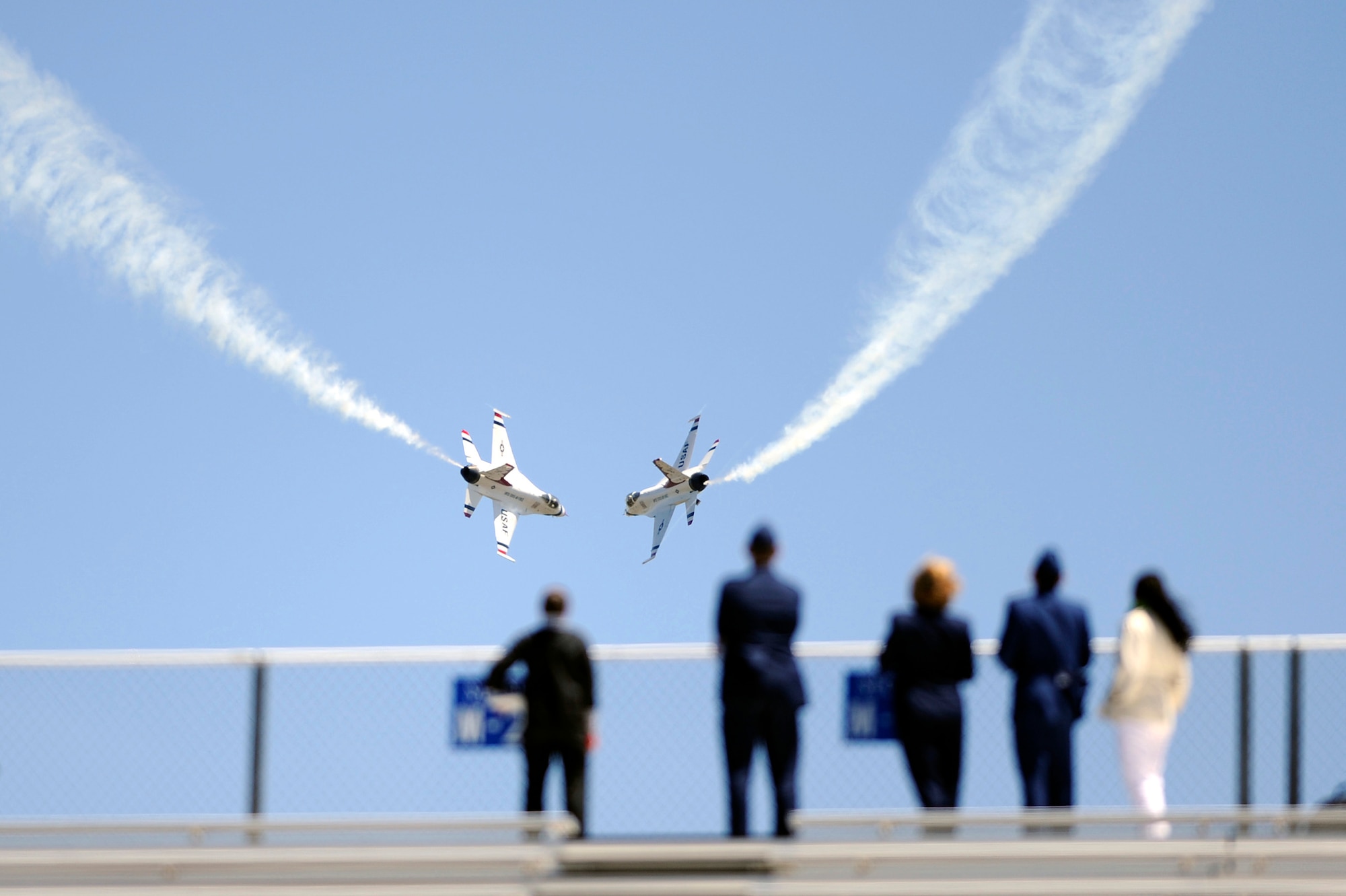 Two Air Force Thunderbirds execute a maneuver over the U.S. Air Force Academy's Falcon Stadium May 27 following the graduation of the Class of 2009.  This was the 51st graduating class where 1,046 cadets were commissioned as second lieutenants.  Vice President Joe Biden was the commencement speaker.  (U.S. Air Force photo/Dennis Rogers)