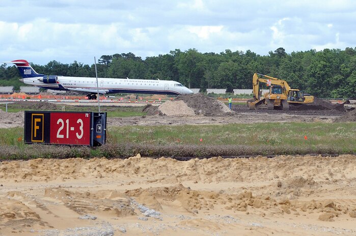 A US Airways Express aircraft taxis down an active runway as contractors work to rebuild runway 03/21 at Charleston AFB May 26. The runway construction is part of a $30 million project to completely replace the deteriorating runway. The runway is being rebuilt using concrete rather than asphalt to allow for a longer life span. The last major repair done on runway 03/21 was in 1968. (U.S. Air Force photo by Staff Sgt. Marie Cassetty)