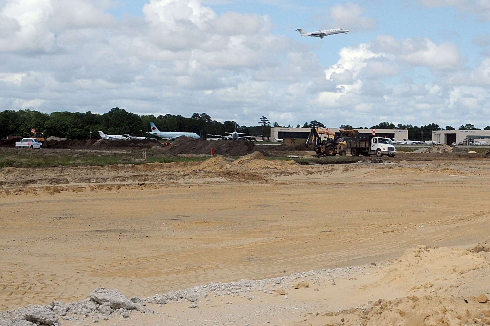 An aircraft  takes off from an active runway as contractors work to rebuild runway 03/21 at Charleston AFB May 26. The runway construction is part of a $30 million project to completely replace the deteriorating runway. The runway is being rebuilt using anywhere between 18 to 24 inches of concrete rather than asphalt to allow for a longer life span. The last major repair done on runway 03/21 was in 1968. (U.S. Air Force photo by Staff Sgt. Marie Cassetty)