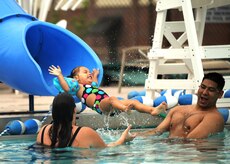 Serenadee Jim glides down the slide to her parents at the base pool May 27. Serenadee is the 2-year-old daughter of Staff. Sgt. Jerome Jim and his wife, Amanda. Sergeant Jim is with the 437th Maintenance Squadron. (U.S. Air Force photo/Senior Airman Timothy Taylor)