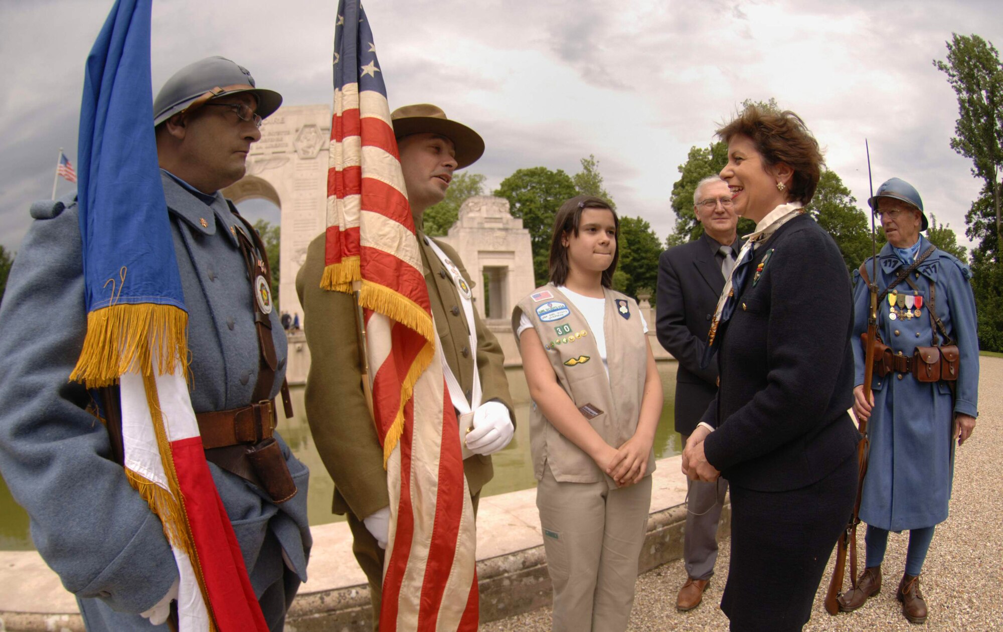 Americans Dineen Angrisani and her 11-year-old daughter Celine Rivera speak with French soldiers dressed in vintage World War I uniforms at the Lafayette Escadrille memorial ceremony outside of Paris May 23. Ms. Angrisani is the Committee Chair for U.S.A. Girl Scouts Overseas in Paris and is actively involved in annual ceremonies at the memorial. (U.S. Air Force photo/Master Sgt. Scott Wagers) 