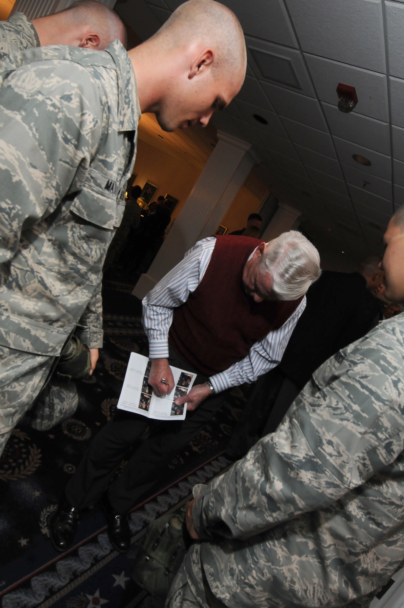 The fifth  Chief Master Sergeant of the Air Force Robert D. Gaylor signs a program for Air Force Honor Guard trainees after a CMSAF room dedication ceremony in the Bolling Club May 26 at Bolling Air Force Base. The room was dedicated to honor our highest enlisted position and provided an opportunity for the newest generation of Airmen to interact with previous generations.  (U.S. Air Force photo by Senior Airman Alex Montes)
