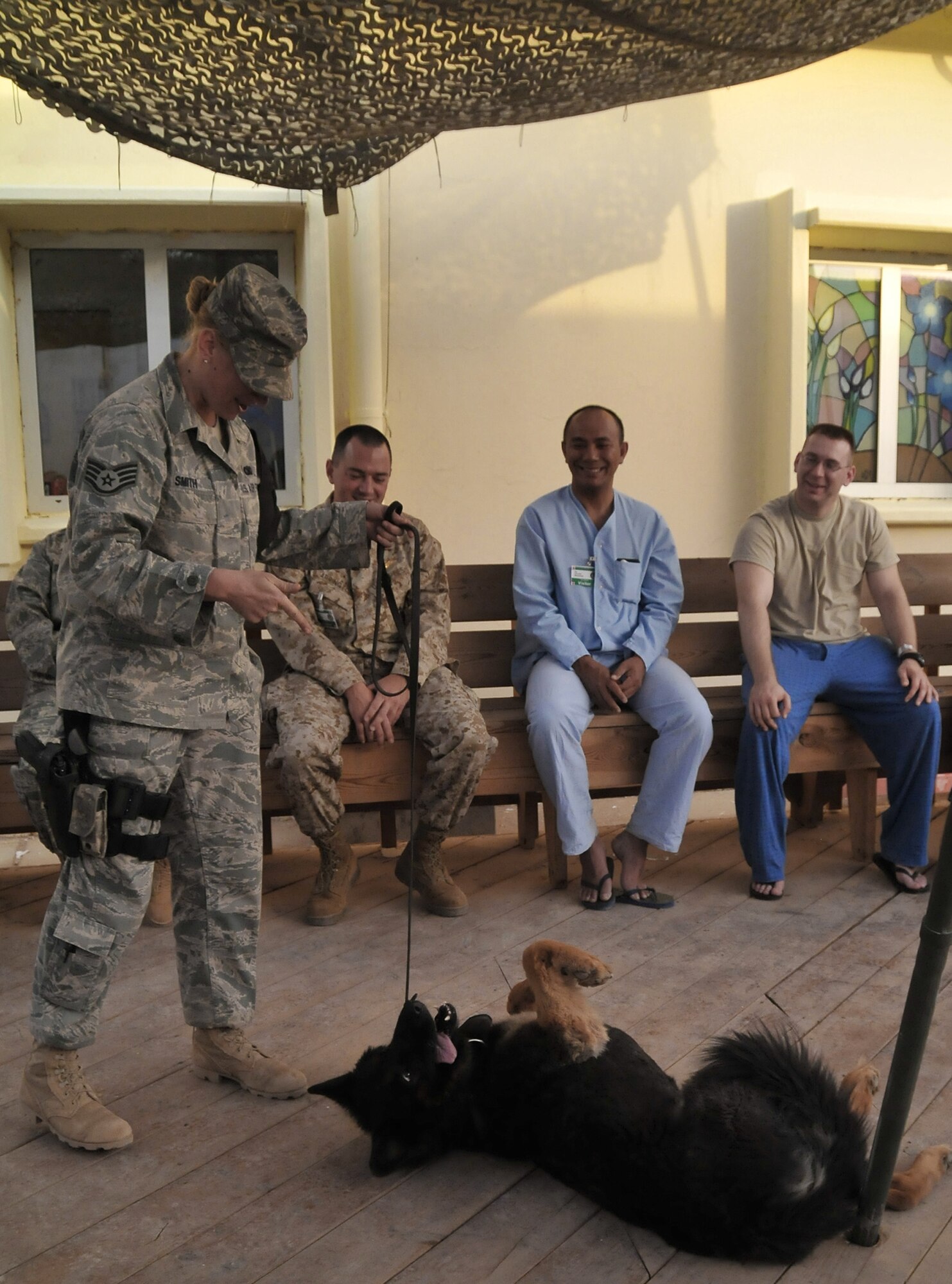 Staff Sgt. Kristen Smith and her explosives-detection military working dog, Cezar, put on a demonstration for patients at the Air Force Theater Hospital as part of the newly created K-9 Visitation Program May 15 at Joint Base Balad, Iraq. The program works to further patient recovery after injury or illness through animal-assisted therapy. Sergeant Smith is a 332nd Expeditionary Security Forces Group K-9 handler. She and her dog are deployed from McGuire Air Force Base, N.J. Sergeant Smith is a native of Johnstown, Pa. (U.S. Air Force photo/Staff Sgt. Dilia Ayala) 
