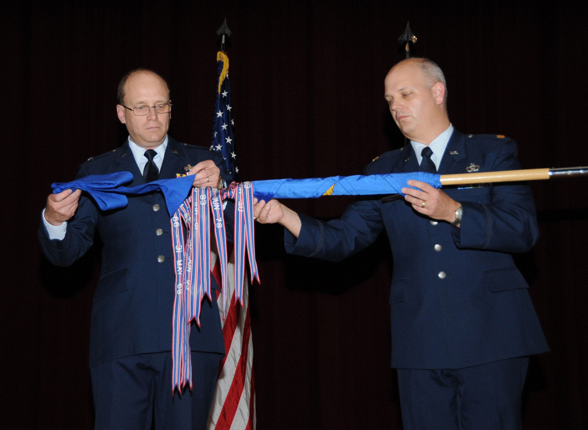 Col. Jeffrey Jackson, left, and Maj. Patrick Breaux furl and sheathe the guidon of the 81st Civil Enginer Squadron during Friday’s deactivation ceremony at Welch Auditorium.  Colonel Jackson commands the 81st Mission Support Group.  Major Breaux commanded the 81st CES.  Most of the squadron’s functions have been assumed by CSC.  Those that weren’t contracted, including the fire department, housing office and Katrina recovery project management office, have been transferred to the 81st MSG’s infrastructure support division.  (U.S. Air Force photo by Kemberly Groue)