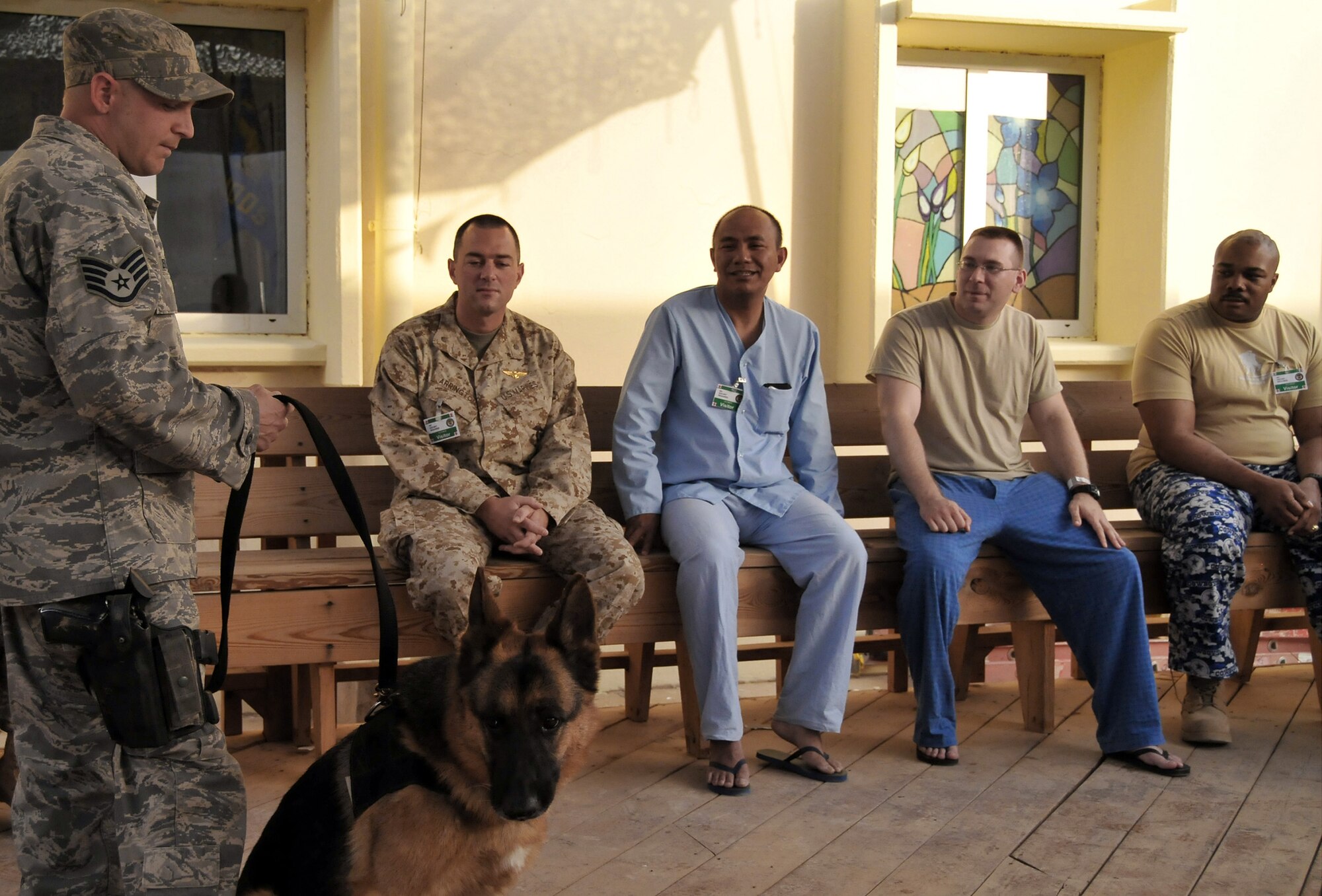 Staff Sgt. Charles Busha introduces his narcotics detector dog, Golf, to patients at the Air Force Theater Hospital as part of the newly created K-9 Visitation Program May 15 at Joint Base Balad, Iraq. Sergeant Busha is a 332nd Expeditionary Security Forces Group K-9 handler. He and his dog are deployed from Fairchild Air Force Base, Wash. Sergeant Busha is a native of Lake Jackson, Texas. (U.S. Air Force photo/Staff Sgt. Dilia Ayala) 
