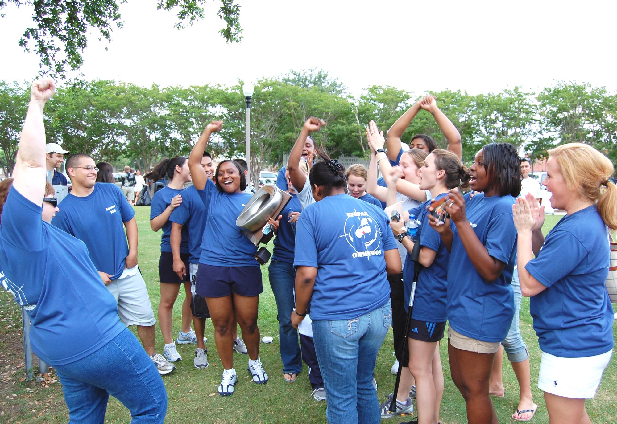 Captain Henry holds the Golden Bedpan Trophy as the Keesler team celebrates its first title in the annual Scrub Shirt Scramble on Biloxi’s Town Green.  (U.S. Air Force photo by Steve Pivnick)