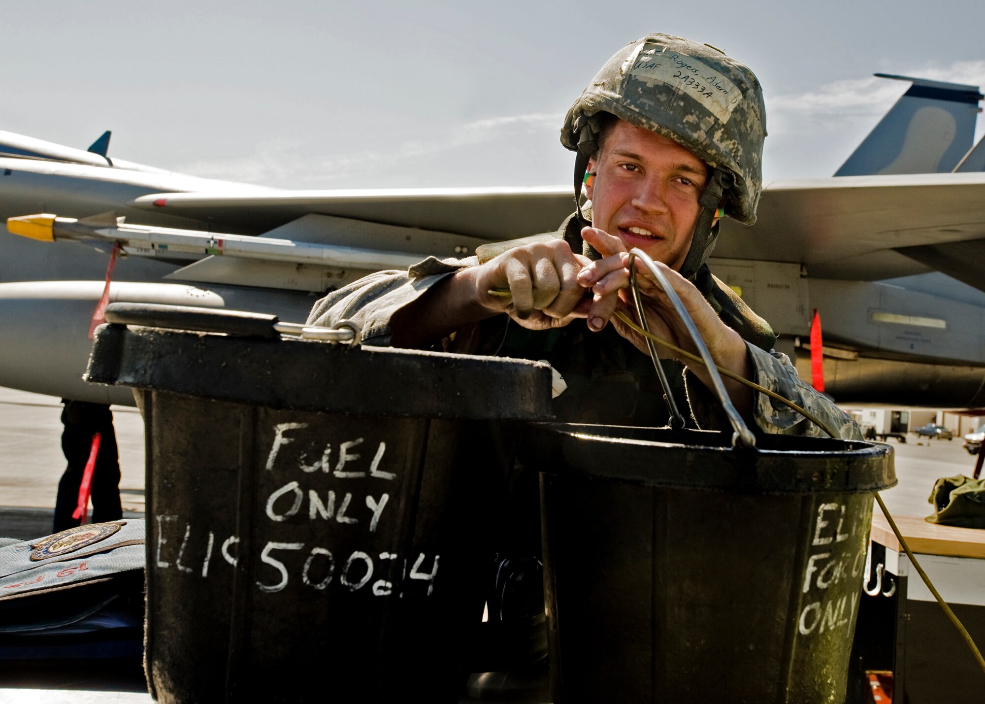ELMENDORF AIR FORCE BASE, Alaska -- Airman 1st Class Adam Rogers, 19th Air Maintenance Unit, secures fuel buckets to his toolbox with a cable during Polar Force 09-05 May 19, 2009. The exercise helped to prepare base members for the upcoming Operational Readiness Inspection beginning June 1. (U.S. Air Force/Senior Airman Laura Turner)