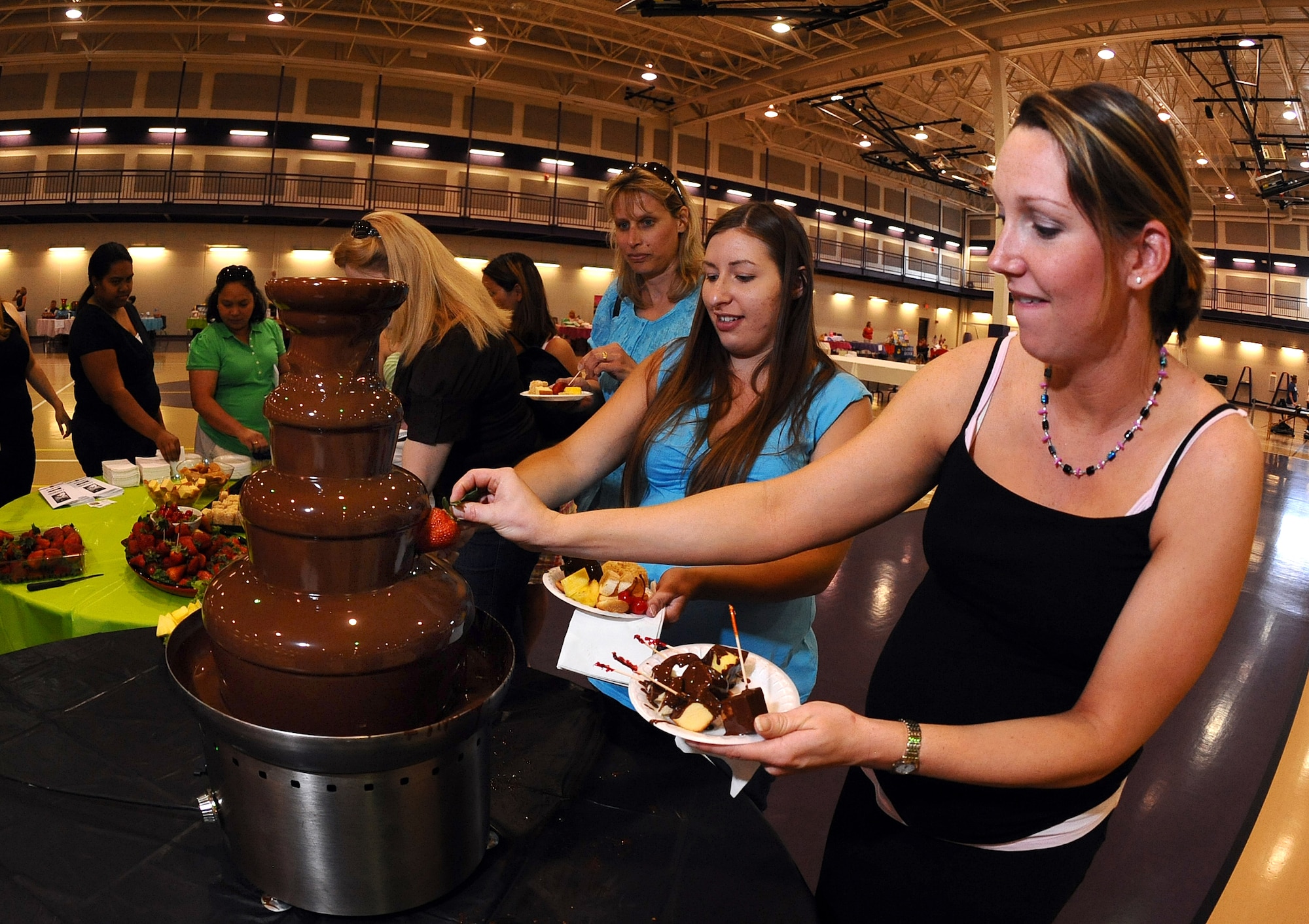 OFFUTT AIR FORCE BASE, Neb. -- Ameilia Fiser, spouse of Capt. Eric Fiser from Wright Patterson AFB, Ohio, dips a strawberry into flowing chocolate during the 2009 Spring Spa for Spouses at the Bellevue Lied Activity Center May 21. Almost 400 spouses attended the event, which consisted of a free dinner, fashion show, massages, manicures and much more. U.S. Air Force Photo by Josh Plueger
