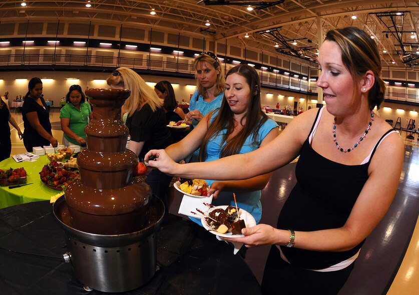 OFFUTT AIR FORCE BASE, Neb. -- Ameilia Fiser, spouse of Capt. Eric Fiser from Wright Patterson AFB, Ohio, dips a strawberry into flowing chocolate during the 2009 Spring Spa for Spouses at the Bellevue Lied Activity Center May 21. Almost 400 spouses attended the event, which consisted of a free dinner, fashion show, massages, manicures and much more. U.S. Air Force Photo by Josh Plueger

