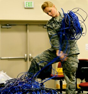 Airman 1st Class Felicia Liotino gathers a mass of network wiring May 19 at the Education and Training Center here. The wiring was installed to provide computer connectivity for inspectors during a base-wide inspection. The custom computer and telecommunications setup provided inspectors with the tools needed to communicate among one another and ensured an expedited inspection. Airman Liotino is a network infrastructure technician assigned to the 437th Communications Squadron. (U.S. Air Force photo/Staff Sgt. Daniel Bowles)