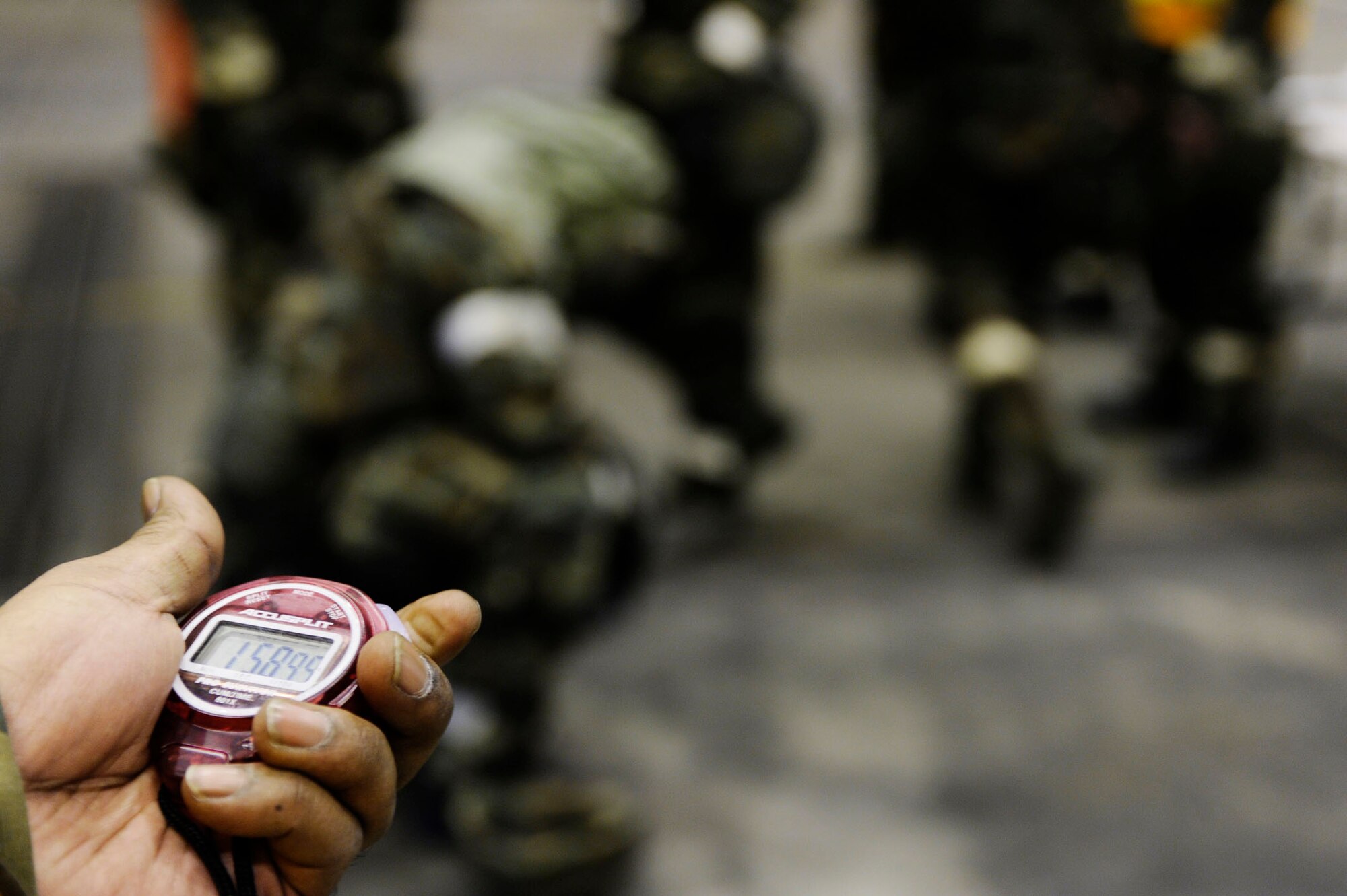 Senior Master Sgt. Cleofas Trejo monitors the stop watch making sure Airman have their mission oriented protective posture level four equipment on before the time runs out during an ability to survive and operate in a war-time environment evaluation training May 21, 2009, Eielson Air Force Base, Alaska. The operational readiness exercise is designed to test capabilities of deployment readiness and operations in support of war-time tasking. Sergeant Trejo is assigned to the 354th Force Support Squadron.  (U.S. Air Force Photo/Senior Airman Jonathan Snyder)