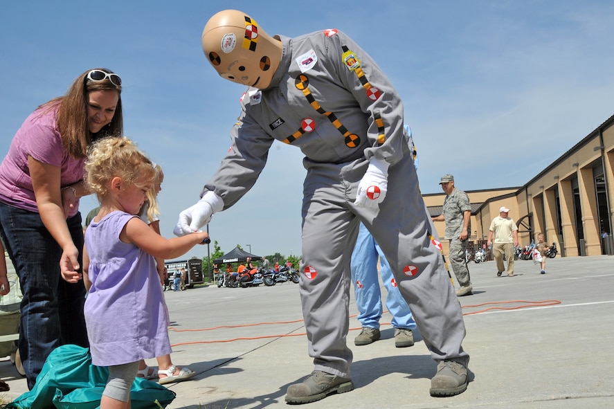 OFFUTT AIR FORCE BASE, Neb. -- Nora Panter, age 2, daughter of Holly Panter and Maj. Jake Panter, 55th Wing, receives a sticker from a crash test dummy, while her mother looks on during a safety fair at the Offutt Fire House May 21. Safety fair patrons enjoyed numerous activities including a seat-belt simulator and a motorcycle-show-and-shine. The safety fair was part of Offutt's annual Safety Day, which focuses on reminding all Airmen to practice safety on a daily basis. Offutt's 2010 Safety Day is set for May 27. U.S. Air Force Photo by Jeff W. Gates 

