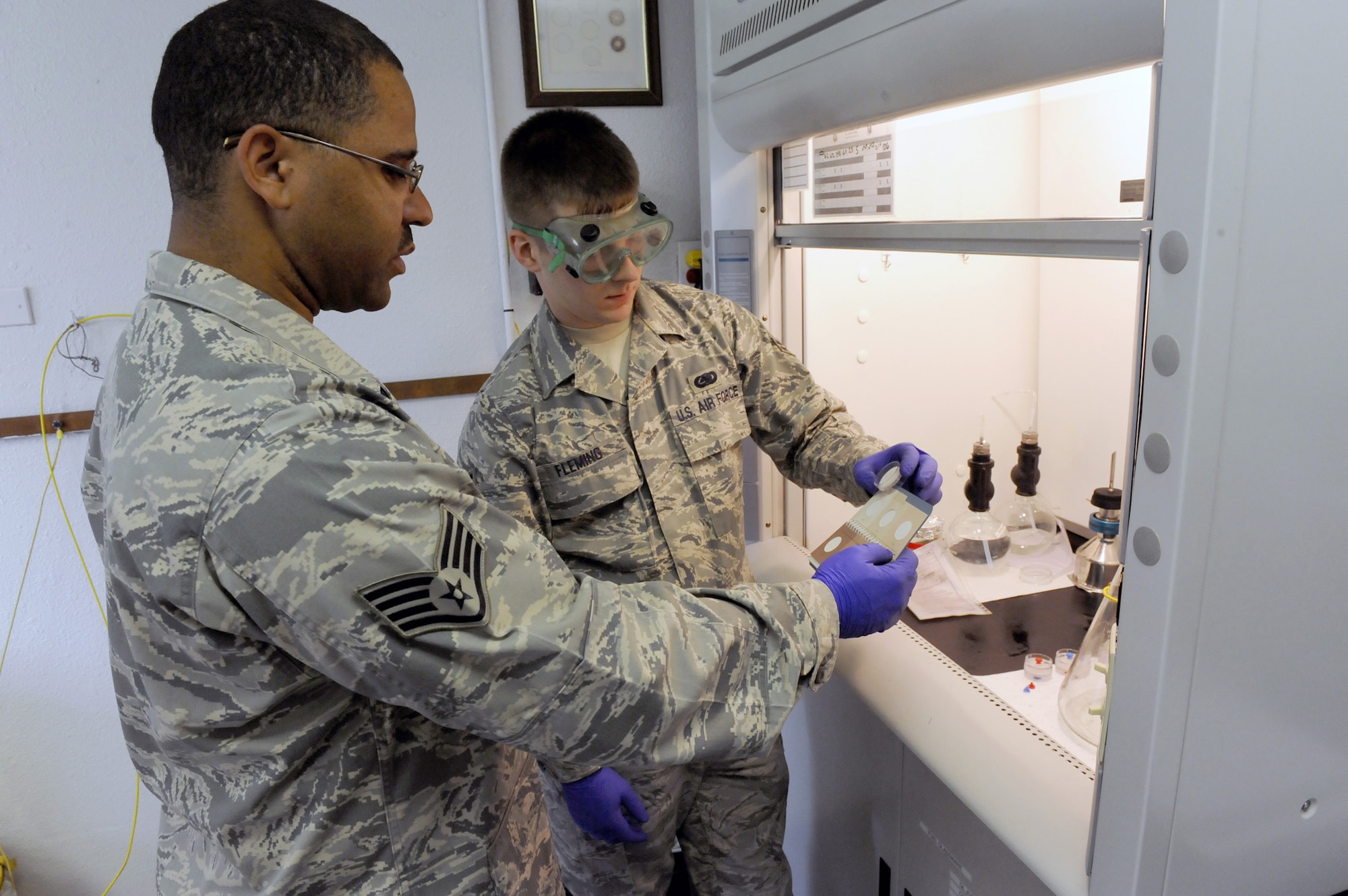 MINOT AIR FORCE BASE, N.D. -- Staff Sgt. Isaac Robinson, 5th Logistics Readiness Squadron fuels laboratory non commissioned officer in charge, and Airman 1st Class John Fleming, 5th LRS fuels laboratory technician, perform quality control procedures on aircraft fuel here May 26. The fuels laboratory checks the water content, color and contamination level of the fuel weekly to ensure its safe usage in aircraft. (US Air Force photo by Staff Sgt. Keith Ballard)