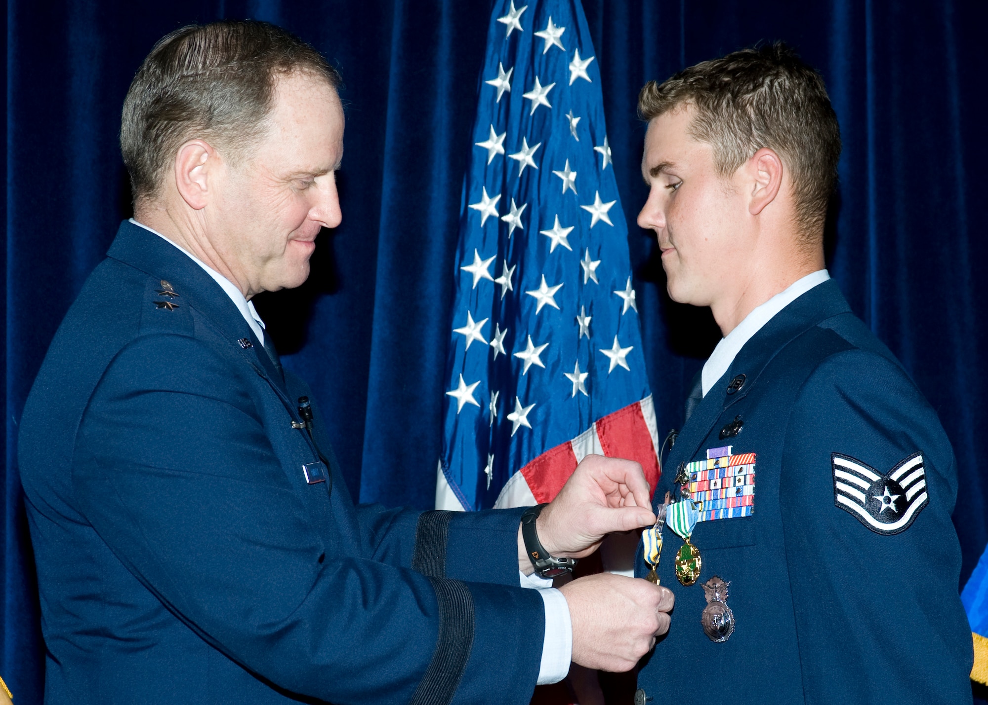 Staff Sgt. Nick Bradley, 96th Security Forces Squadron, receives a commendation medal from Maj. Gen. Jay Lindell during his retirement ceremony May 21 at Eglin Air Force Base.  Sergeant Bradley was wounded when an improvised explosive device exploded near his vehicle as he was serving with a convoy traveling in Afghanistan. The blast caused facial fractures, a fractured foot, traumatic right arm injuries and amputation of a finger on his left hand.  Sergeant Bradley received a Purple Heart and the Combat Action Medal from Air Force Chief of Staff Gen. Norton Schwartz in October 2008, before being medically retired.  (U.S. Air Force photo/Bruce Hoffman.)