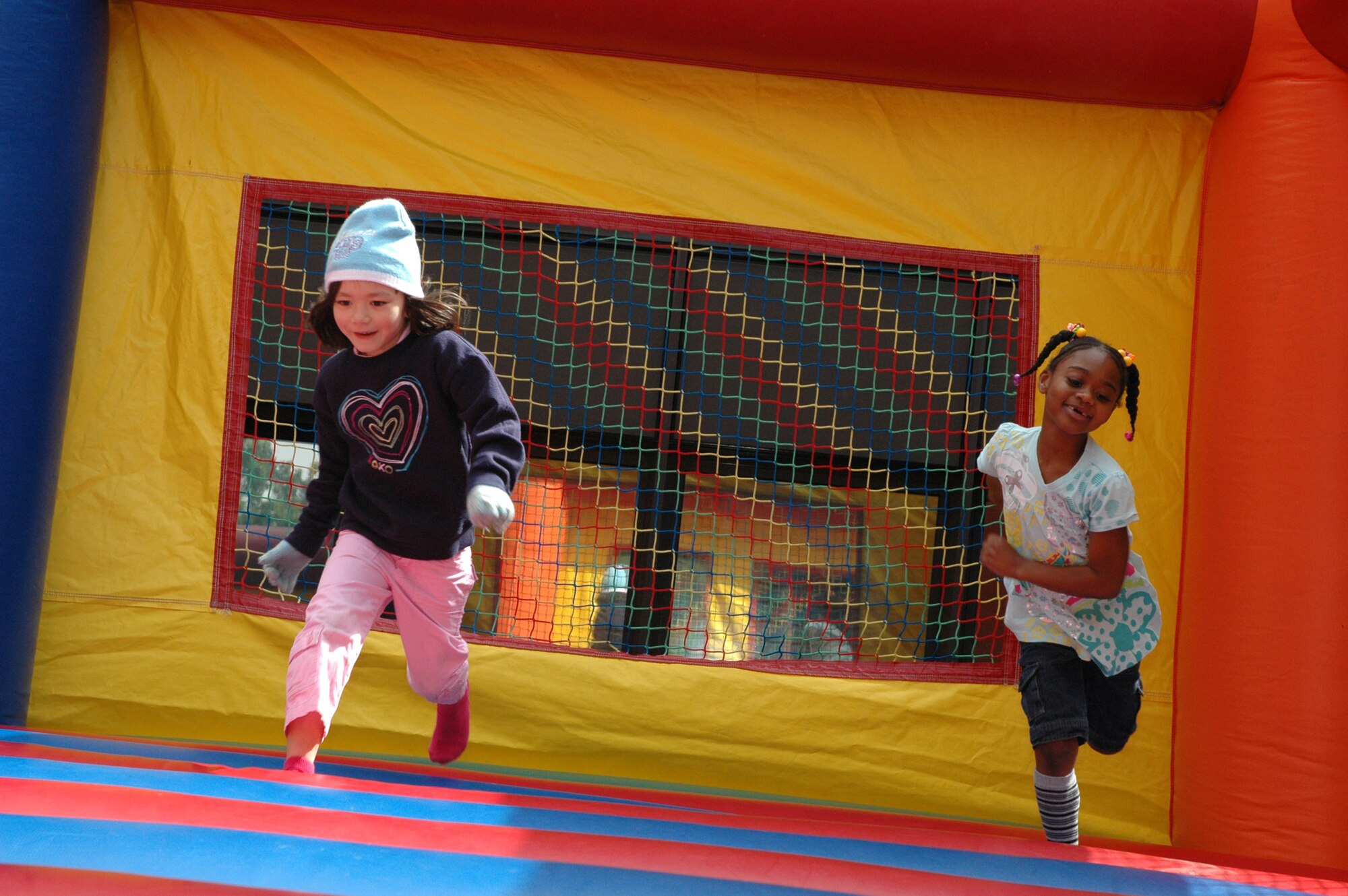 SPANGDAHLEM AIR BASE, Germany -- Emiko Groder and Destinee Daigs try to run in a bouncy castle May 16, 2009 at the Spangdahlem Elementary School Parent-Teacher-Student Association Spring Carnival. (Photo by Bobbie Gonzales)