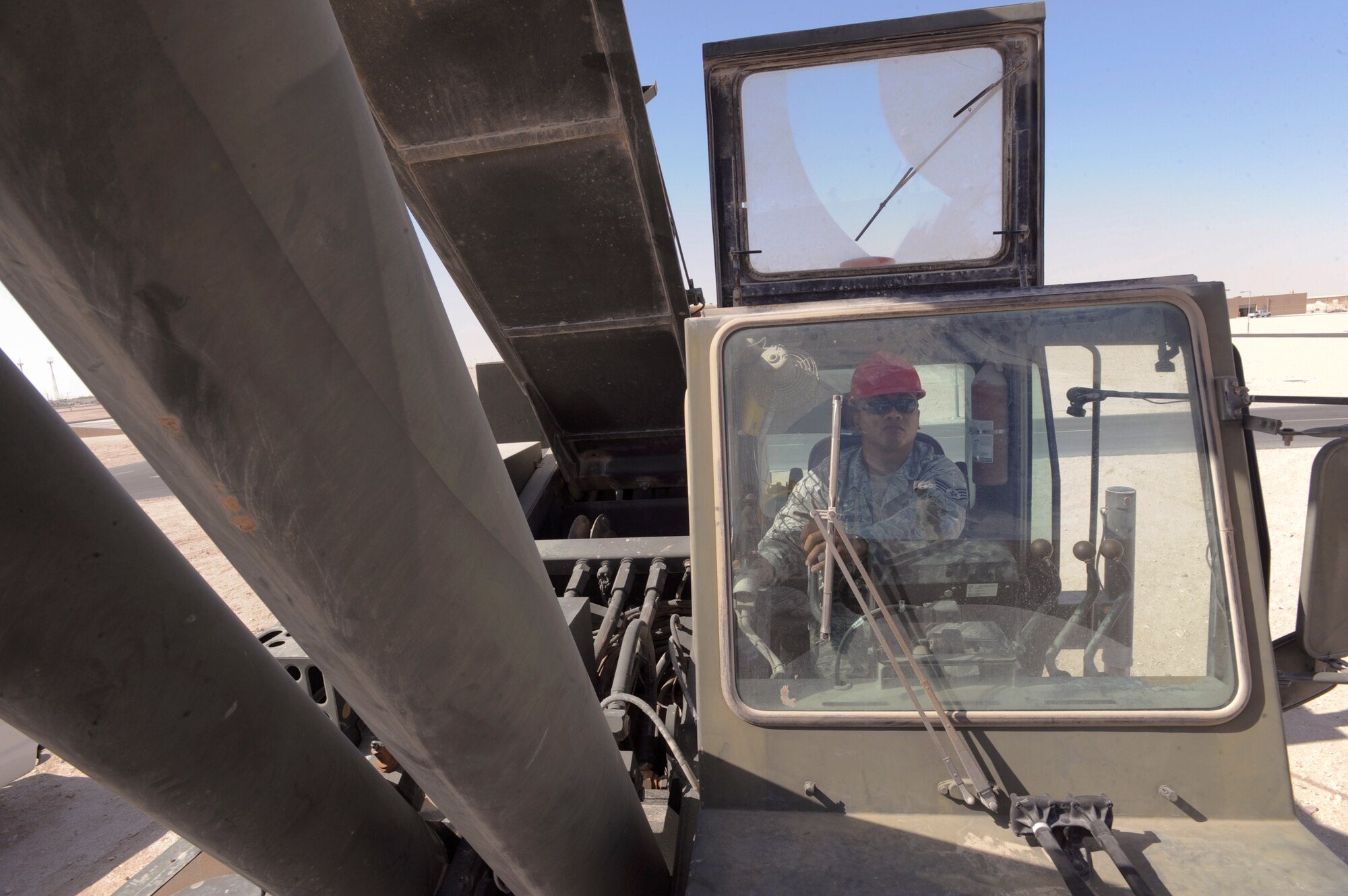 Staff Sgt. Rene Macapagal, a heavy equipment operator with the 379th Expeditionary Civil Engineer Squadron, operates a 60 ton crane to remove an air compressor from a building here, May 26, 2009 in an undisclosed location in Southwest Asia. The crane allows members of the 379th ECES to move large equipment items in a safe manner.  Sergeant Macapagal is native to Honolulu, Hawaii and is deployed from Travis Air Force Base, Calif. in support of Operations Iraqi and Enduring Freedom and Combined Joint Task Force - Horn of Africa.  (U.S. Air Force Photo by Staff Sgt. Joshua Garcia/released)