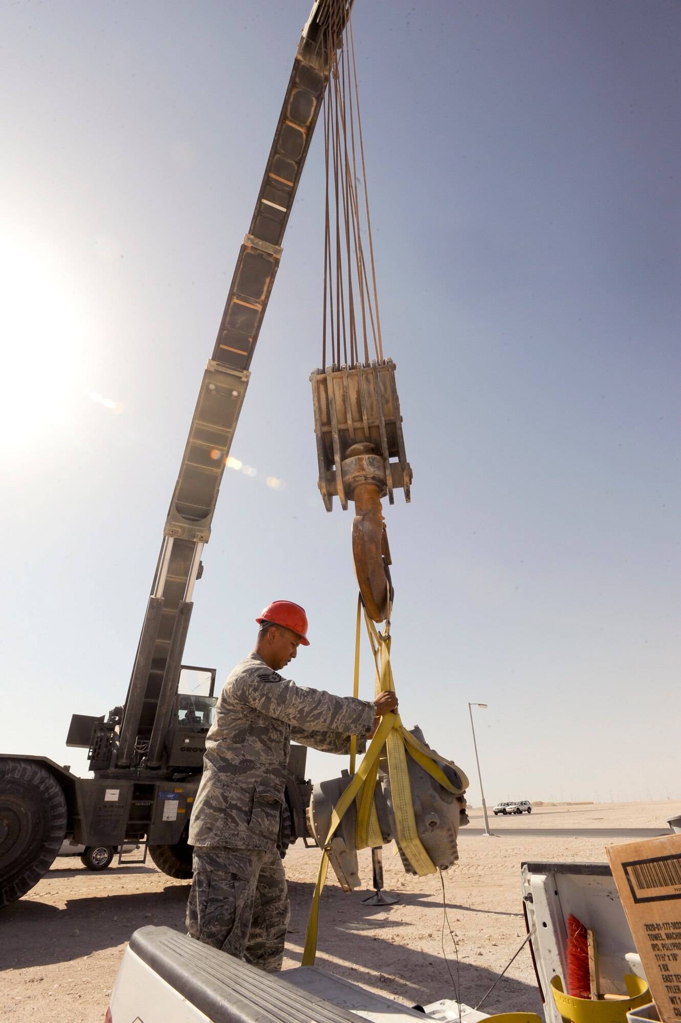 Staff Sgt. Troy Driz, a member of the 379th Expeditionary Civil Engineer Squadron, guides an air compressor held by a 60 ton crane into the truck bed so it can be returned to the shop for repairs, May 26, 2009, in an undisclosed location in Southwest Asia.  The 60 ton crane is used frequently to safely move heavy pieces of equipment. Sergeant Driz is native to the Philippines and is deployed from Nellis Air Force Base, Nev., in support of Operations Iraqi and Enduring Freedom and Combined Joint Task Force - Horn of Africa.  (U.S. Air Force Photo by Staff Sgt. Joshua Garcia/released)