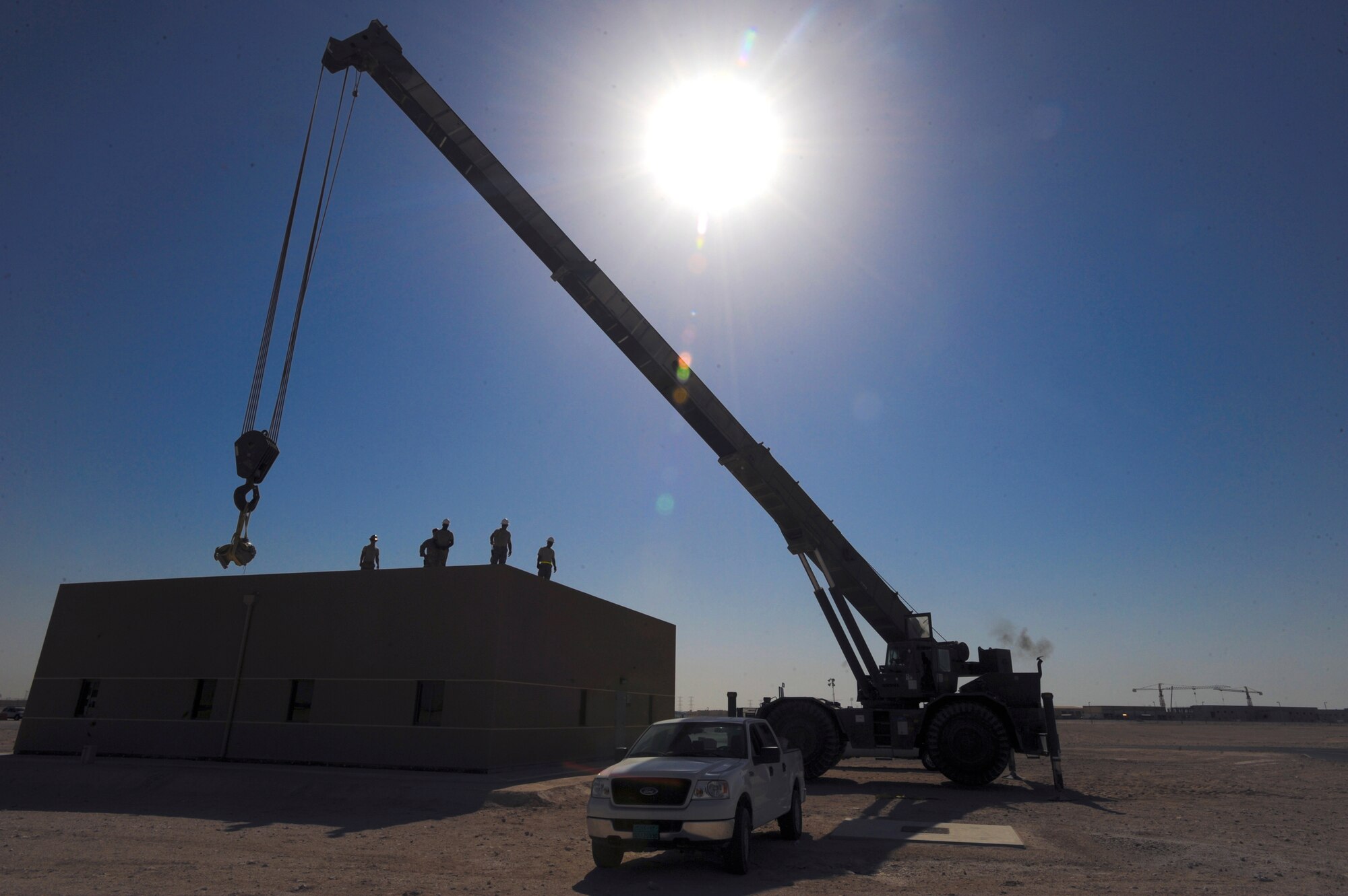 Members from the 379th Expeditionary Civil Engineer Squadron, remove an air compressor for an air conditioning unit from a rooftop with a 60 ton Grove crane, 26 May, 2009, in an undisclosed location in Southwest Asia.  The move required two different shops, Heating, Ventilation and Air Conditioning and the Heavy Equipment shop, working together to ensure the compressor is moved in a safe and timely manner.  All members are deployed in support of Operations Iraqi and Enduring Freedom and Combined Joint Task Force - Horn of Africa.  (U.S. Air Force Photo by Staff Sgt. Joshua Garcia/released)