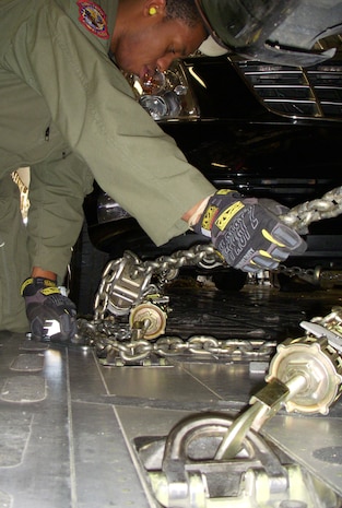 Senior Airman Alfonso Rogers, 15th Airlift Squadron loadmaster, tightens down for the last time several chains securing Vice President Joseph Biden's motorcade May 27 at Peterson Air Force Base, Colo. Vice President Biden attended and spoke at the U.S. Air Force Academy's graduation, where fourth-year cadets received not only their degree, but their commissions as second lieutenants in the U.S. Air Force. Airman Rogers, a native of Warner Robins, Ga., is based at Charleston AFB in South Carolina. (U.S. Air Force photo/Senior Airman Stephen J. Collier)