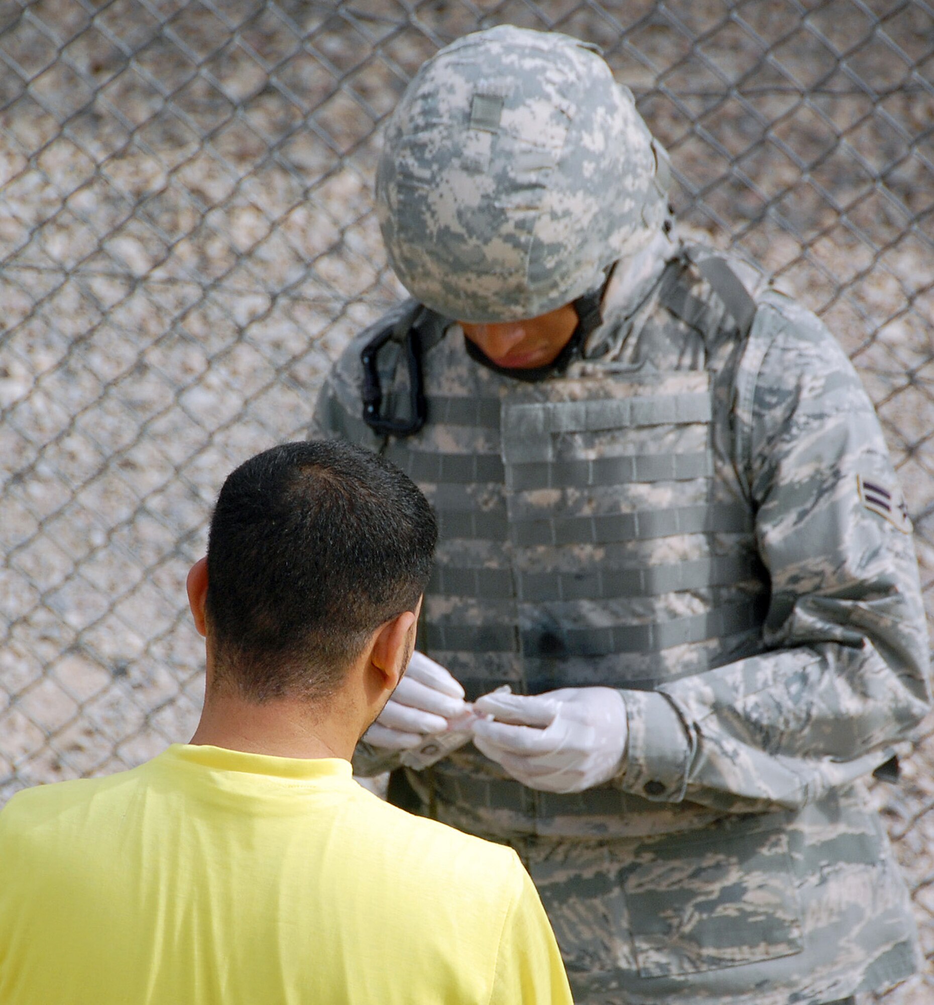 A searcher with the 887th Expeditionary Security Forces Squadron conducts a search of a detainee before a visit with his family  May 12 at the Theater Internment Facility's visitation center at Camp Bucca, Iraq. Security Forces Airmen working at the visitation center are responsible for making sure no contraband makes it into the visitation area while at the same time treating the detainees and their families with the highest degree of dignity and respect. (U.S. Air Force photo/Staff Sgt. Thomas J. Doscher)