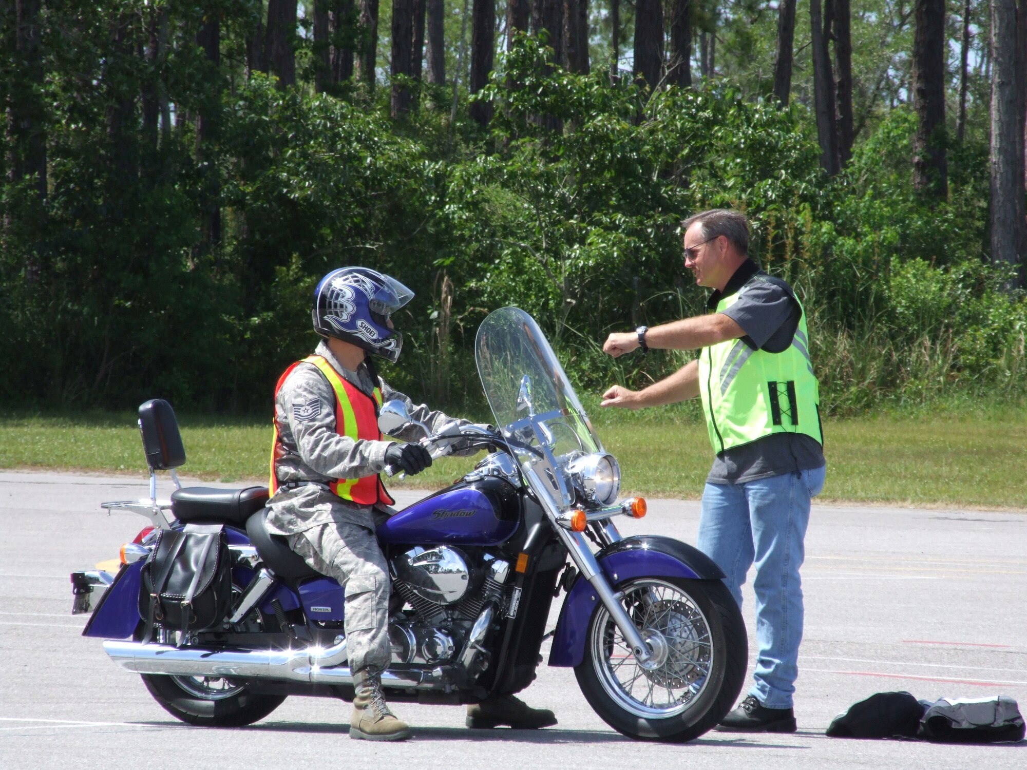Motorcycle Safey Foundation instructor, Master Sgt. Michael McGuire, demonstrates a counterbalance technique to assist a motorcycle rider in slow-speed maneuvering during Air Forces Northern's Safety Day May 21. U.S. Air Force photo by John McDill.