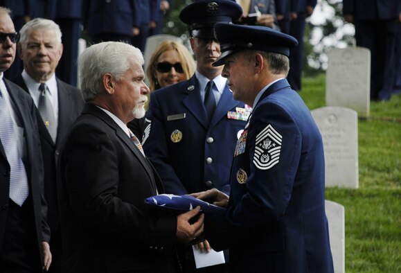 Chief Master Sergeant of the Air Force Rodney J. McKinley presents a flag to retired Chief Master Sgt. Dale Airey, during the memorial service for his father Chief Master Sgt. Paul W. Airey at Arlington National Cemetery, Va., May 28. Chief Airey, serving 27 years, became the first Chief Master Sergeant of the Air Force April 3, 1967, following his installment by then Secretary of the Air Force Harold Brown and Air Force Chief of Staff Gen. John P. McConnell. Chief Airey retired from active duty on Aug. 1, 1970 and died March 11 in Panama City, Fla. Chief Airey and his wife Shirley's remains were buried together at Arlington National Cemetery. (U.S. Air Force photo/Master Sgt. Stan Parker) 
