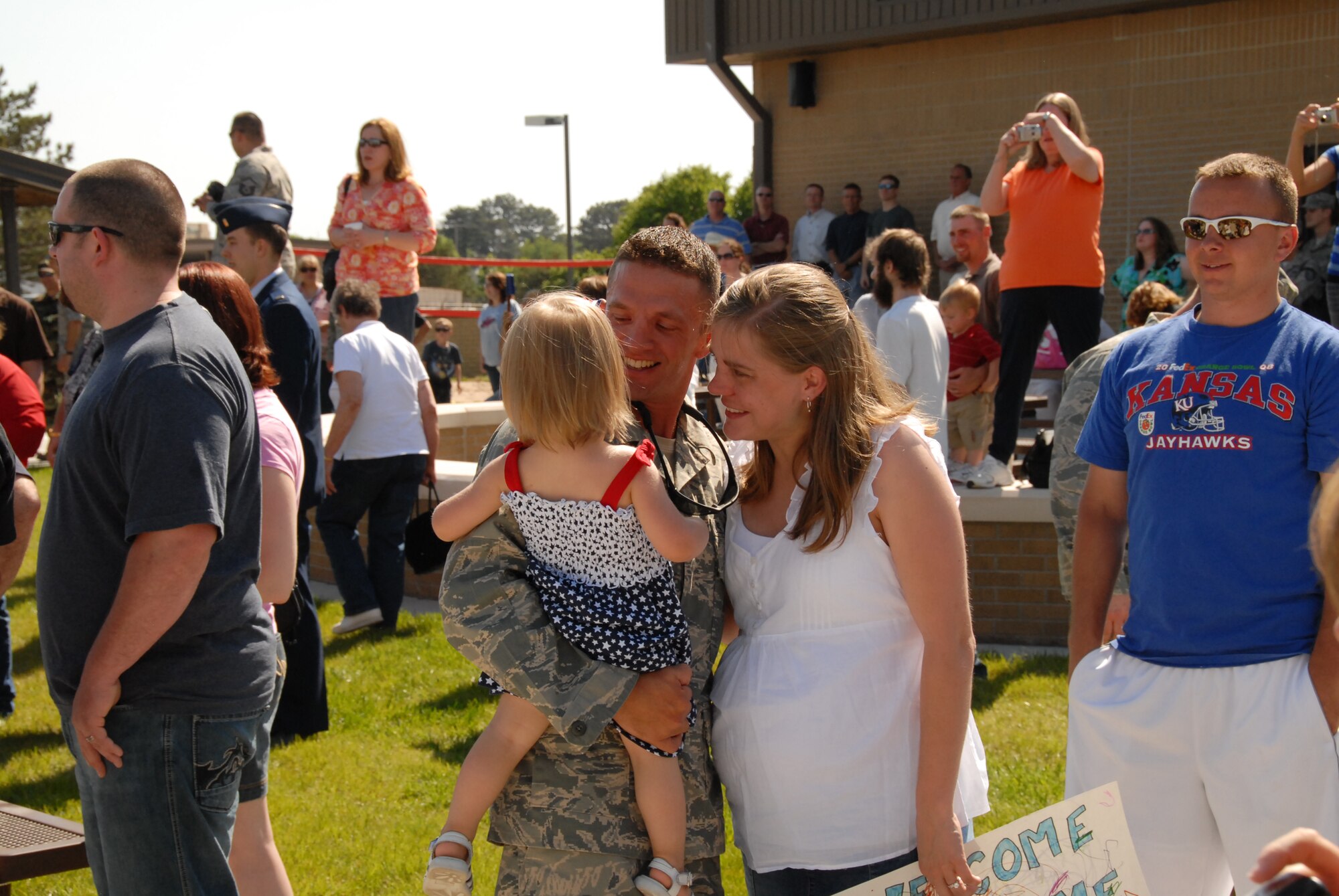 Kansas Air Guard’s 134 Air Control Squadron member, TSgt Justin Moody, gets hugs and kisses from his daughter and wife at the re-deployment ceremony welcoming his unit home from their deployment to Iraq.