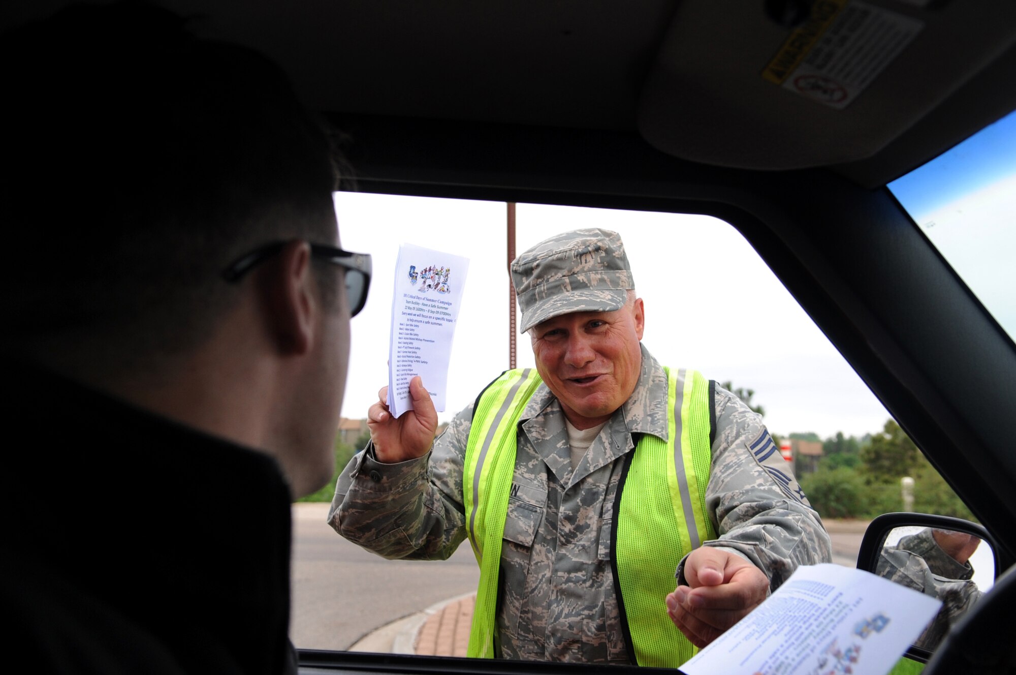 BUCKLEY AIR FORCE BASE, Colo. -- Kicking off the 101 Critical Days of Summer, Chief Master Sgt. James Martin, 460th Civil Engineer Squadron, hands out flyers to members of Buckley as they enter the base. The 101 Critical Days of Summer campaign runs through Labor Day and helps raise awareness for on- and off-duty activities during the summer months. (U.S. Air Force photo by Senior Airman Erika Brooke)