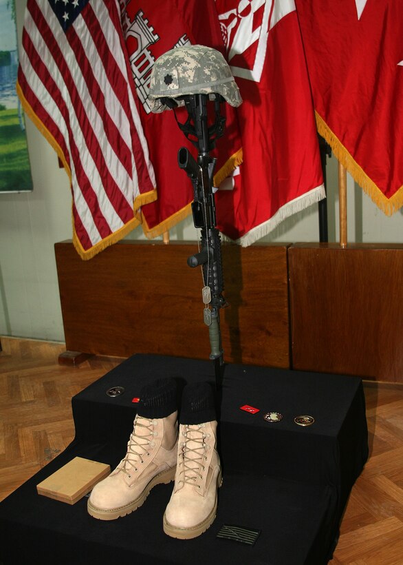 BAGHDAD, Iraq --  A fallen servicemember display for Cmdr. Duane Wolfe. The helmet and identification tags signify the fallen warrior. The inverted rifle signals a time for prayer, a break in the action to pay tribute. The combat boots represent the final march of the last battle. (USACE photo courtesy of F.T. Eyre)