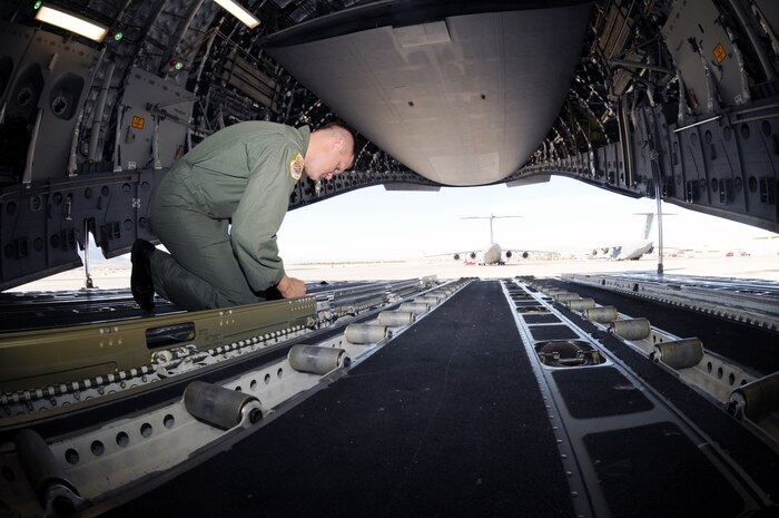 NELLIS AIR FORCE BASE, Nev.--U.S. Air Force Tech. Sgt. Joshua Hoogstra, a C-17 loadmaster assigned to Headquarters Air Mobility Command at Scott AFB, Ill., performs a preflight inspection on a C-17 Globemaster during theMobility Air Forces Exercise (MAFEX), May 20.  Approximately 12  U.S. AirForce bases participate in MAFEX at the U.S. Air Force Weapons School twicea year, testing C-17 Globemasters and C-130 Hercules crew's ability to jointogether in formation at a specific time and location to drop a brigade-sizeforce anywhere in the world. (U.S. Air Force photo Senior Airman BrianYbarbo, released)