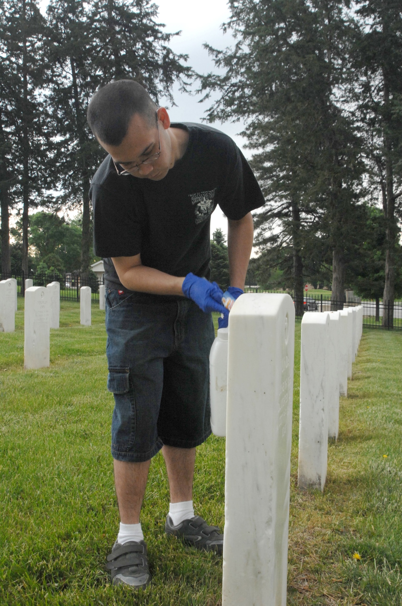 OFFUTT AIR FORCE BASE, Neb. - Senior Airman Kyle M. Kent, 55th Communications Squadron Network Control Center administration technician, cleans one of the headstones inside the Offutt Cemetery in preparation for Offutt's Memorial Day ceremony May 25. U.S. Air Force photo by Leticia Cunningham