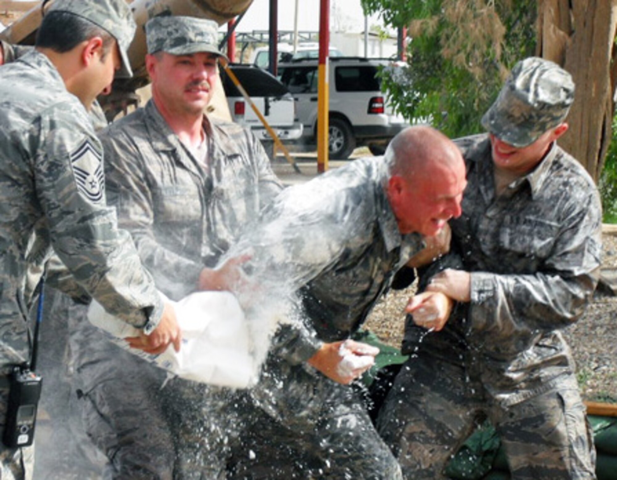 Tech. Sgt. Ted Fussell, 506th Expeditionary Civil Engineer Squadron structural craftsman, gets doused with flour and water during a surprise promotion ceremony for him at Kirkuk Regional Air Base, Iraq, May 21, 2009. Sergeant Fussell is a firefighter with the Anchorage, Alaska, Fire Department, and recently promoted to senior captain. The act of dousing a firefighter with flour and water is a long-standing tradition within the fire department. Sergeant Fussell is a reservist with Air Force Reserve Command's 477th Fighter Group, an F-22 classic associate unit, at Elmendorf Air Force Base, Alaska. (Courtesy photo)