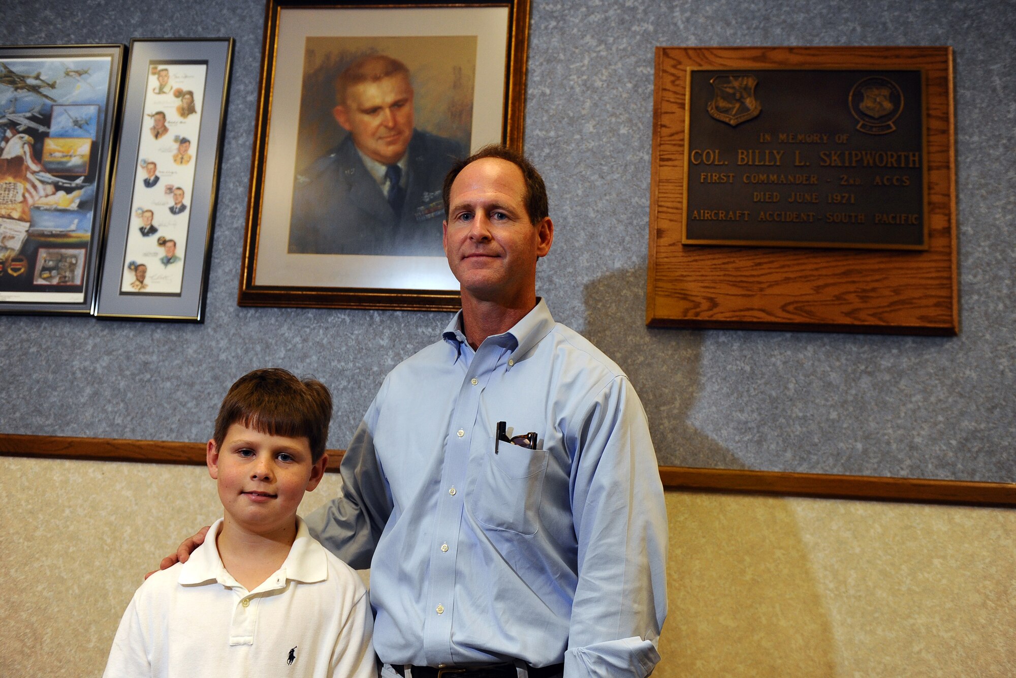 OFFUTT AIR FORCE BASE, Neb. ? Timothy A. Skipworth and his son William pose for a photo in front of a painting of Timothy's father, Col. Billy L. Skipworth, inside the Billy L. Skipworth Operations Center here May 23. The building was named after Col. Skipworth after he died in a plane crash in the South pacific on June 13, 1971. Col. Skipworth was the commander of the 2nd Airborne Command and Control Squadron. Timothy was 8-years-old when his father died. The visit was his first to Offutt since he was a young boy. U.S. Air Force Photo by Josh Plueger

