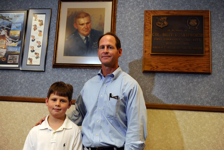 OFFUTT AIR FORCE BASE, Neb. ? Timothy A. Skipworth and his son William pose for a photo in front of a painting of Timothy's father, Col. Billy L. Skipworth, inside the Billy L. Skipworth Operations Center here May 23. The building was named after Col. Skipworth after he died in a plane crash in the South pacific on June 13, 1971. Col. Skipworth was the commander of the 2nd Airborne Command and Control Squadron. Timothy was 8-years-old when his father died. The visit was his first to Offutt since he was a young boy. U.S. Air Force Photo by Josh Plueger