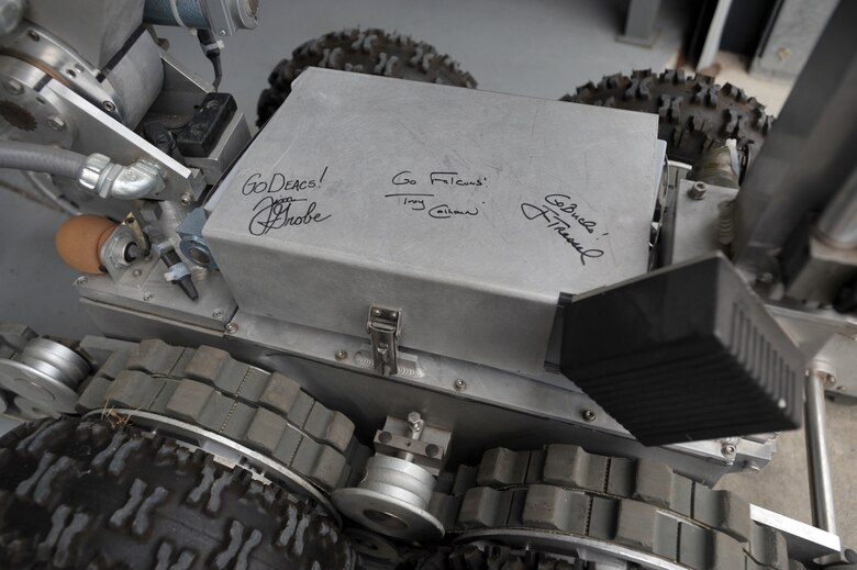 Three NCAA football coaches who visited McConnell Air Force Base, Kan., on May 27, took time to sign a robot used during exposive ordnance disposal missions. The coaches--Troy Calhoun of Air Force, Jim Grobe of Wake Forest, and Jim Tressel of Ohio State--were at the base to start Coaches Tour 2009, a second annual morale-boosting mission that brings icons of college football to U.S. servicemembers. (U.S. Air Force photo/Tech. Sgt. Jason Schaap)