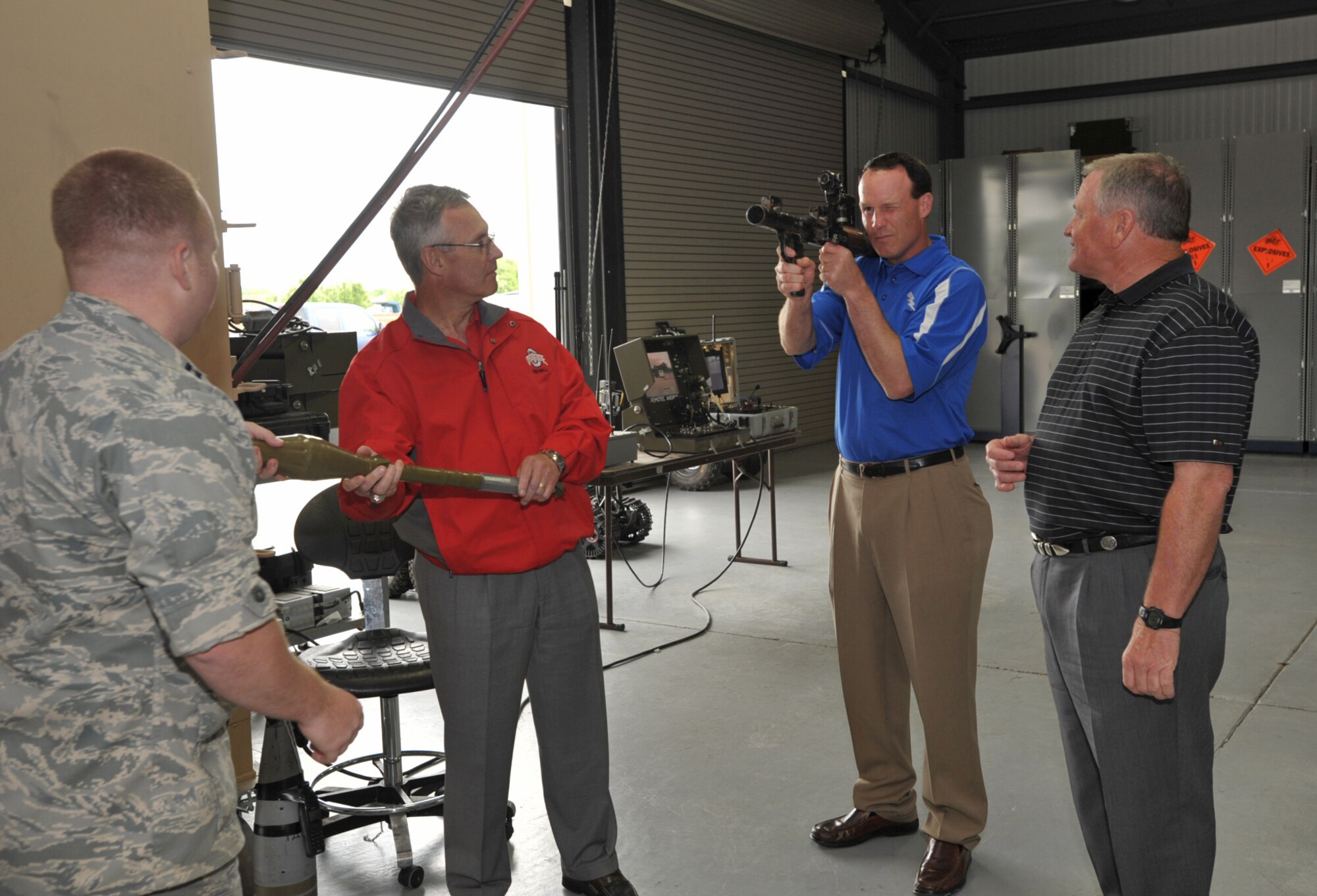 Troy Calhoun, head coach of the Air Force football team, takes aim with a foreign-made grenade launcher during a demonstration at McConnell Air Force Base, Kan., on May 27. To his left is Jim Grobe, head football coach at Wake Forest, and to his right is Jim Tressel, head coach at Ohio State. The coaches visited McConnell at the kickoff of Coaches Tour 2009, a second-annual morale-boosting mission that brings college football icons to U.S. servicemembers. Also pictured is Capt. George Haka, member of the explosive ordnance disposal team at McConnell that provided the coaches several demonstrations. (U.S. Air Force photo/Tech. Sgt. Jason Schaap)