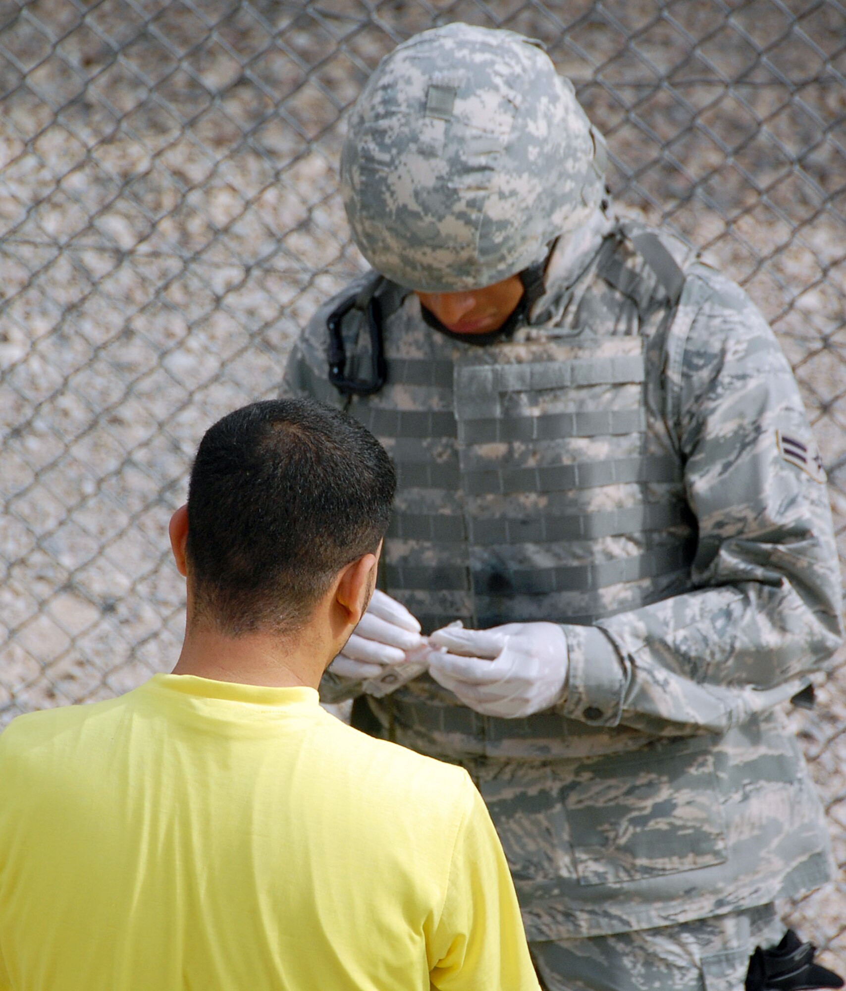 CAMP BUCCA, Iraq – A searcher with the 887th Expeditionary Security Forces Squadron conducts a search of a detainee before a visit with his family at the Theater Internment Facility’s visitation center at Camp Bucca, Iraq, May 12. Security Forces Airmen working at the visitation center are responsible for making sure no contraband makes it into the visitation area while at the same time treating the detainees and their families with the highest degree of dignity and respect. (U.S. Air Force photo by Staff Sgt. Thomas J. Doscher)